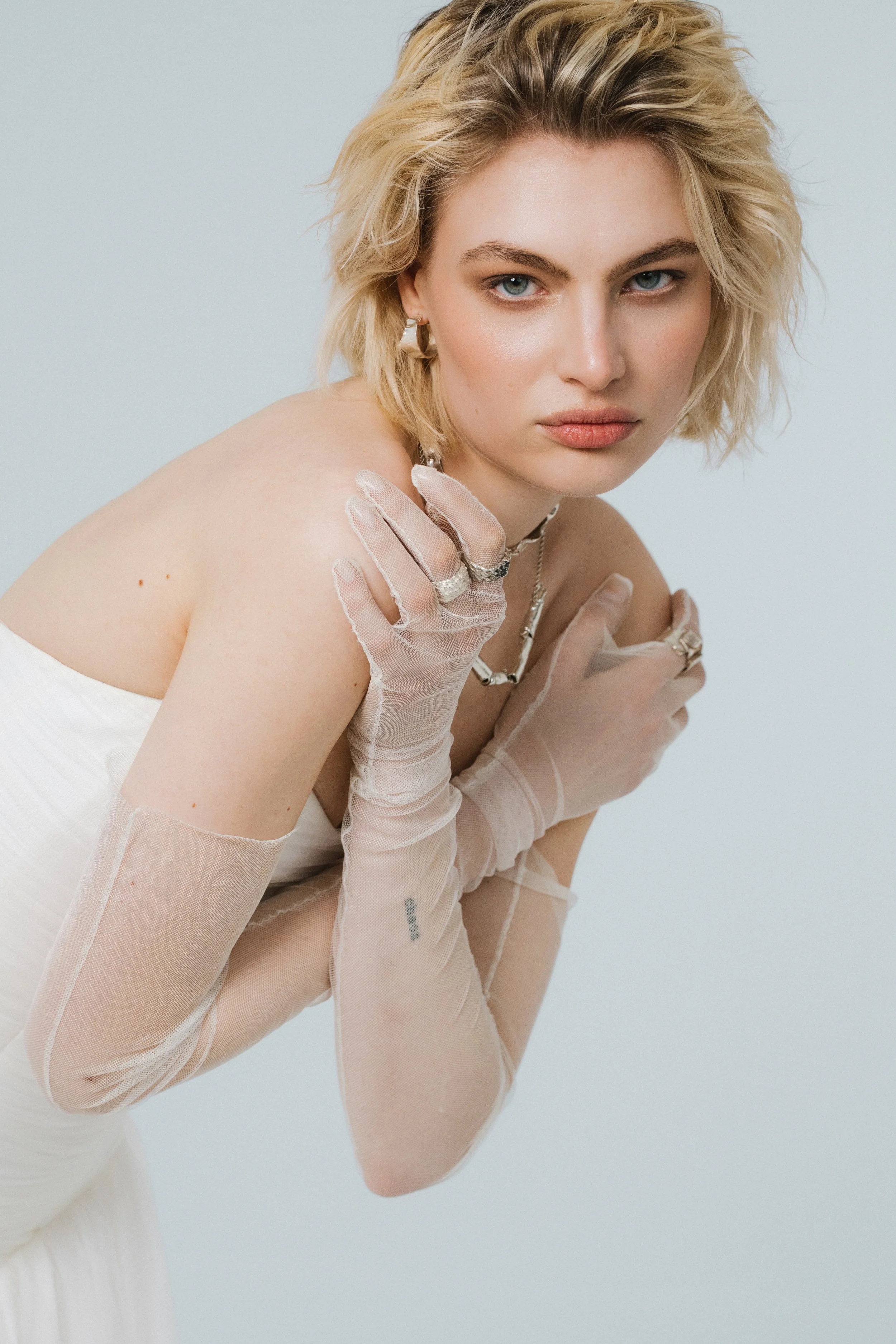 Sheer soft tulle bridal gloves with extra-long gathered silhouette styled for modern bridal looks