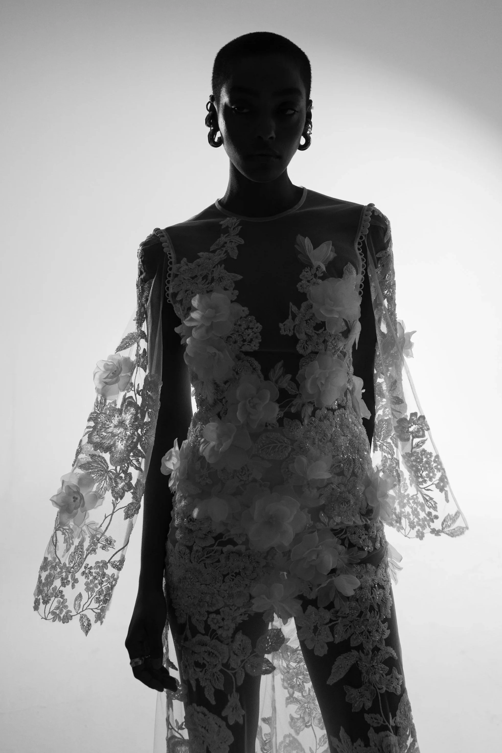 Dramatic editorial image of a bridal couture dress with lace and floral details