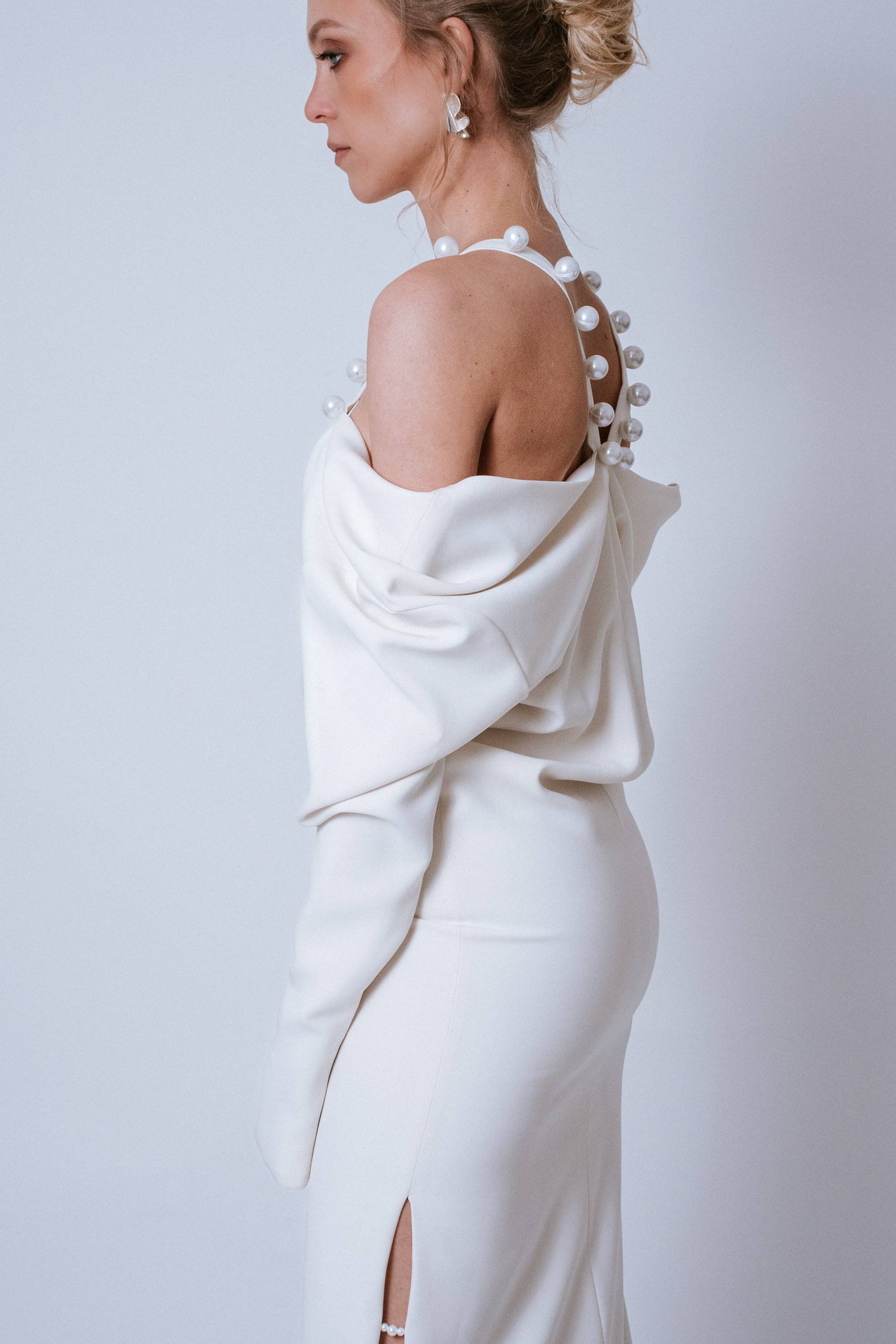 Alternate side angle of Sharp Dress showing off-shoulder sleeve and silhouette contrast