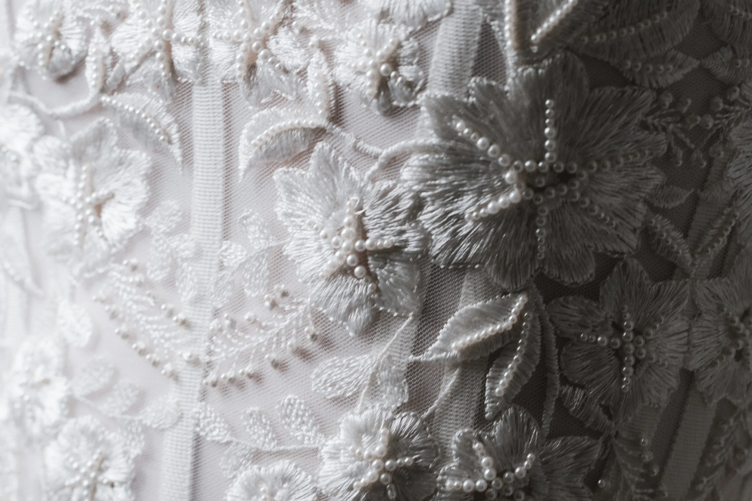 Close-up of embroidered lace, bow details and visible boning on the Ceremony Corset