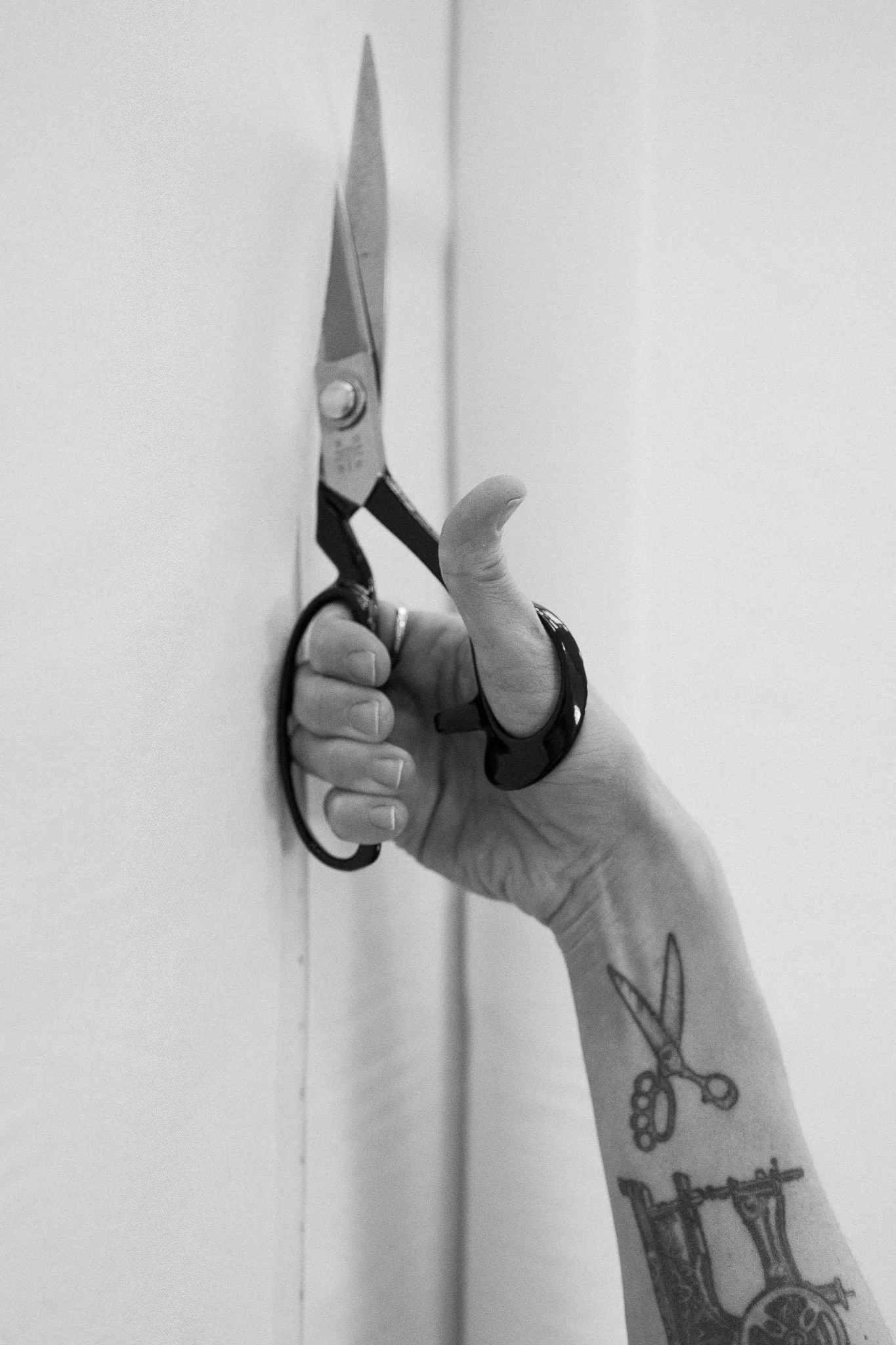 Close-up of a designer’s hand cutting fabric, symbolising handcrafted bridal couture
