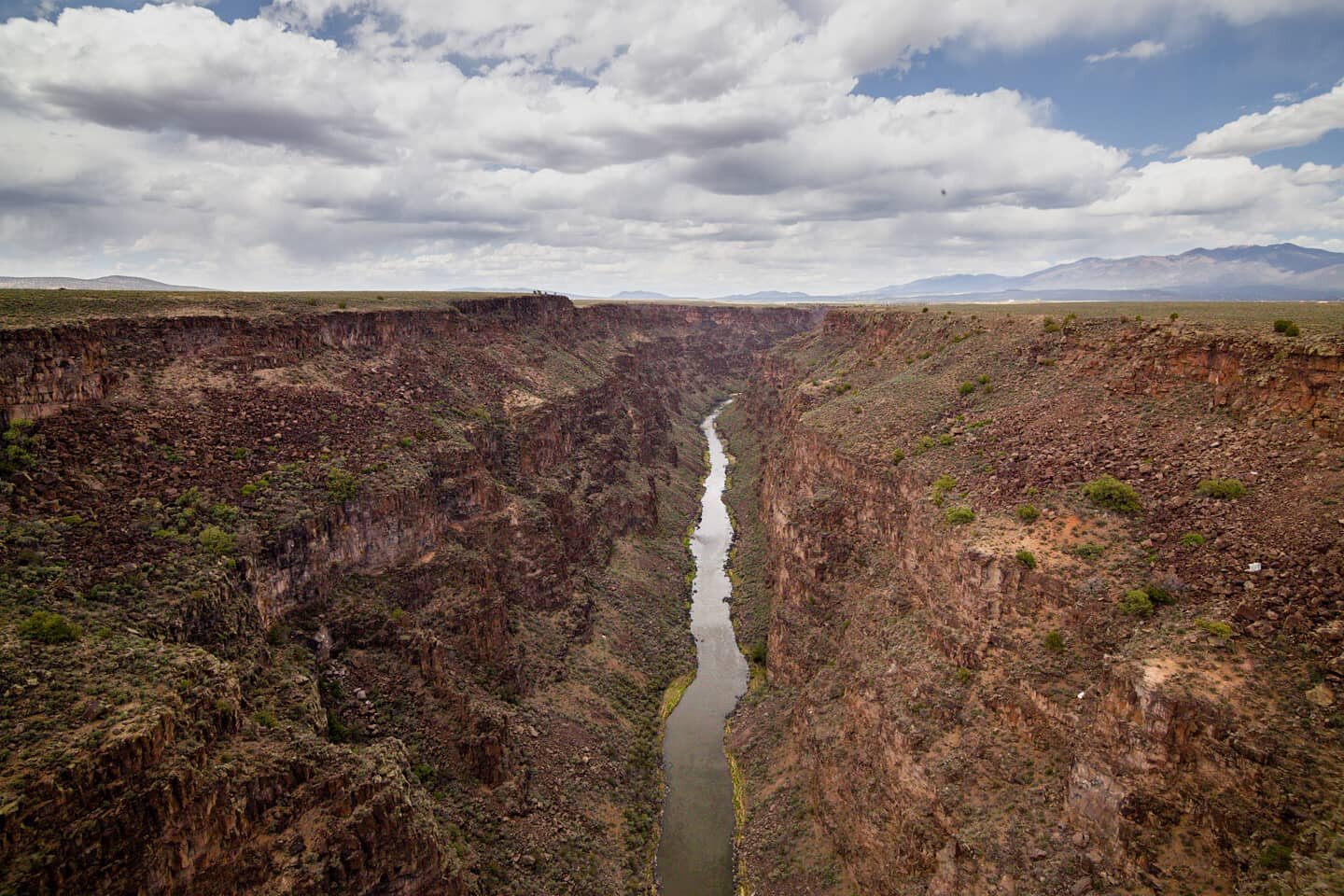 The Rio Grande has cut deep. The view from the Rio Grande Gorge Bridge overlooks this jagged canyon, leading the water to a vanishing point somewhere near the horizon.