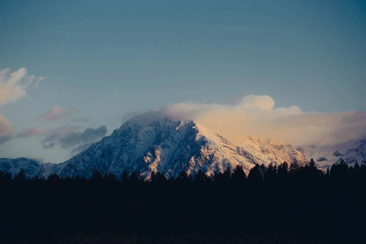 I like this capture because within it, is almost a summary of all the colors you'll see in a sunrise. The dawn's dark but blue light fades off the backside of the mountain. The multicolored phase takes center. The final sunrise stage of a golden shim