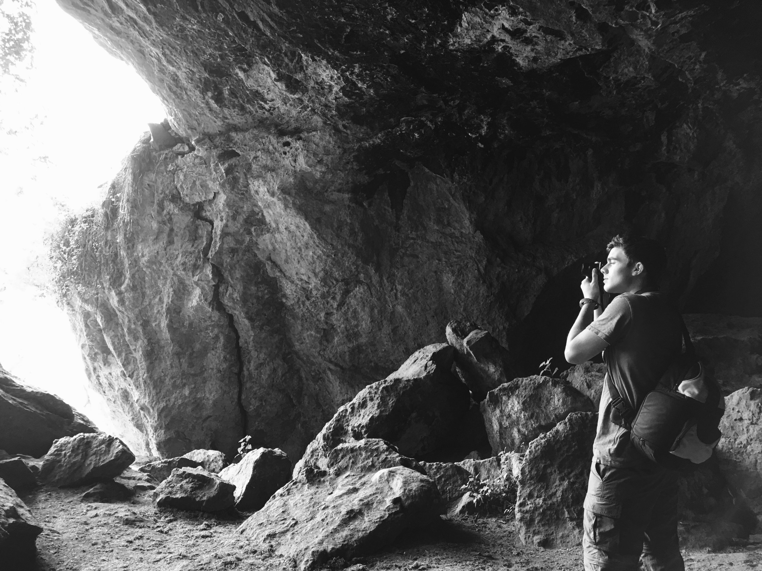 Hunter trying to capture a picture of the hanging moss at the entrance of the cave.