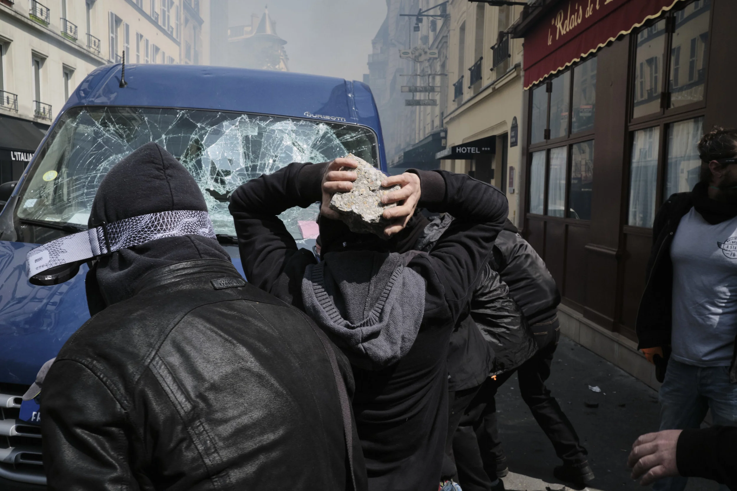 Anti-fascist participants of the protests are destroying a parked van after pushing back the police to the Rui Vavin.