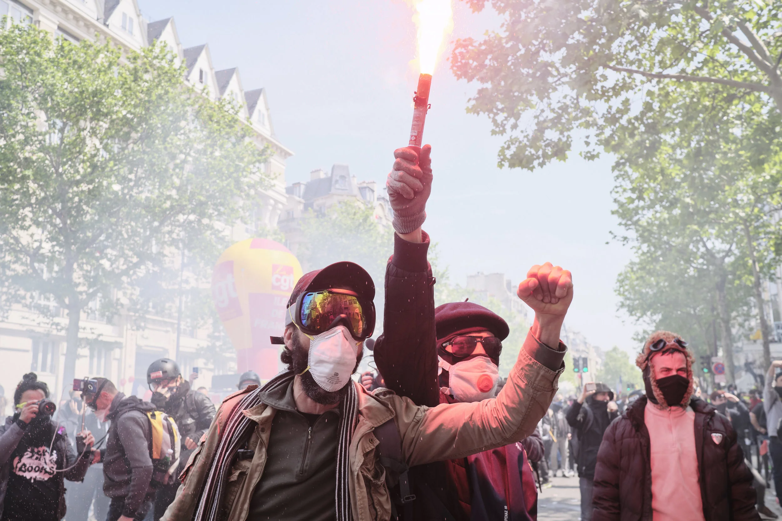 Protest participants celebrating with light flairs after successfully withstanding a crowd control manoeuvre by the police at Boulevard du Montparnasse.