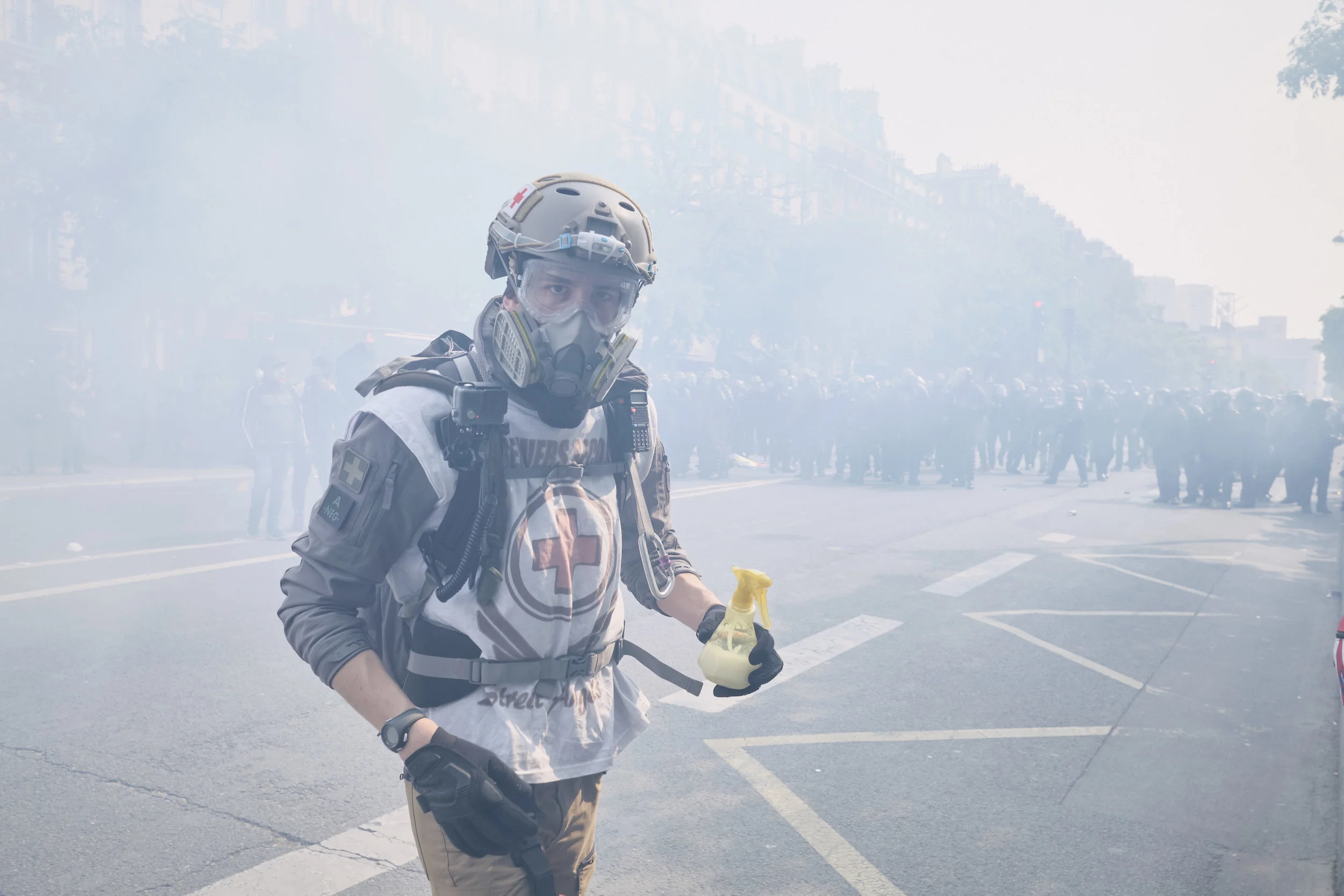 Civilian street medic on his way to help an injured protest participant right after an attempt by the police to control the crowd using tear gas at The Avenue des Gobelins.