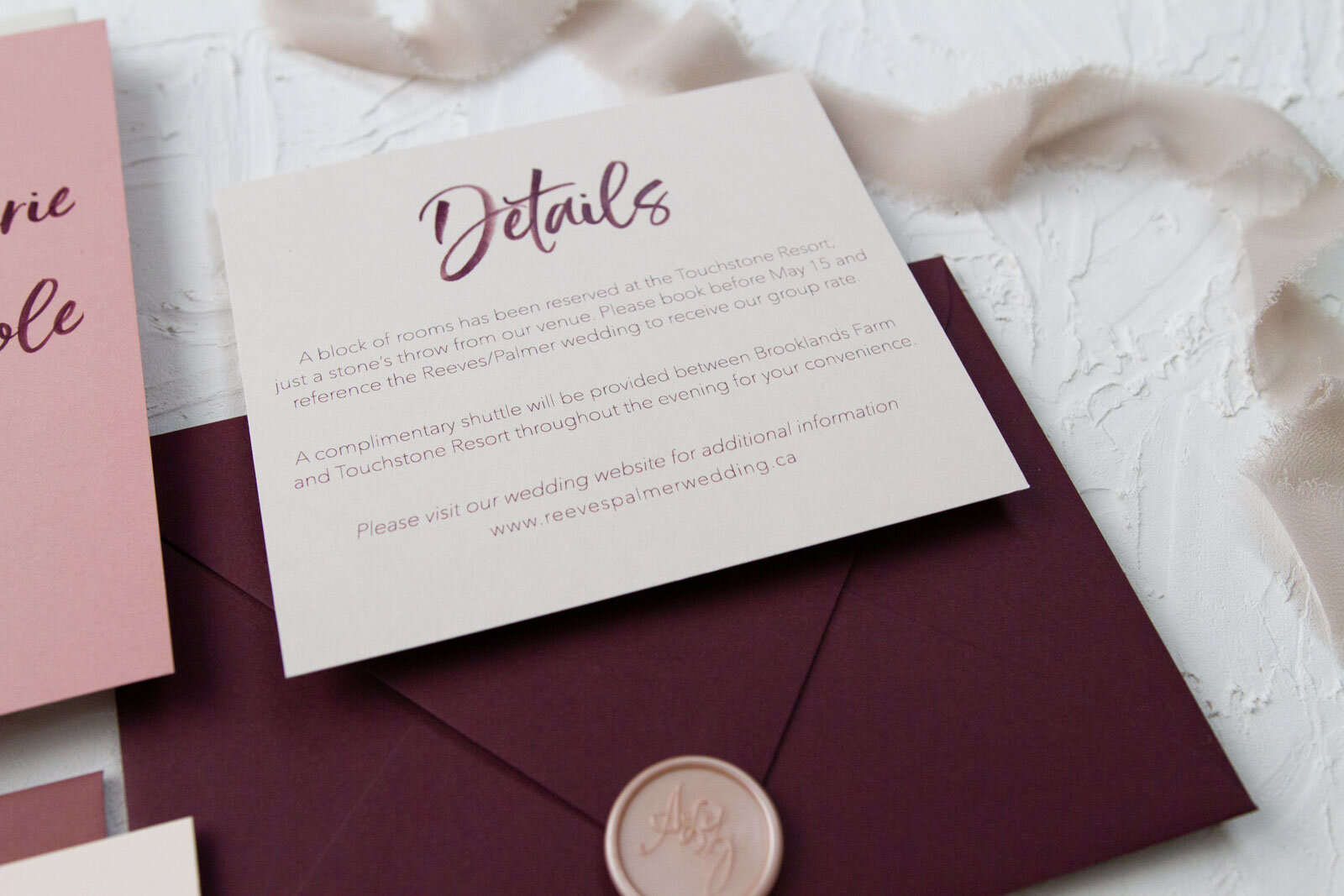 Detailed look at the details card with burgundy watercolour script title and personalized wedding ceremony and reception details.