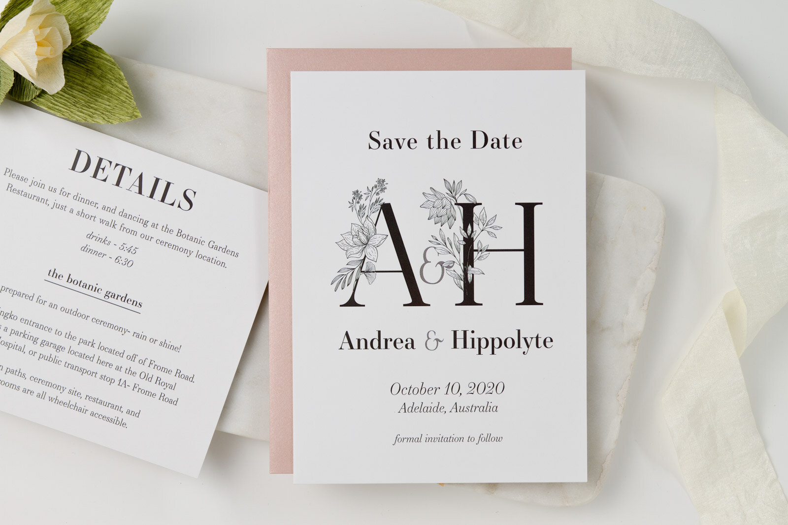  A classic black and white save the date card with prominent initials intertwined with detailed floral line drawings. 