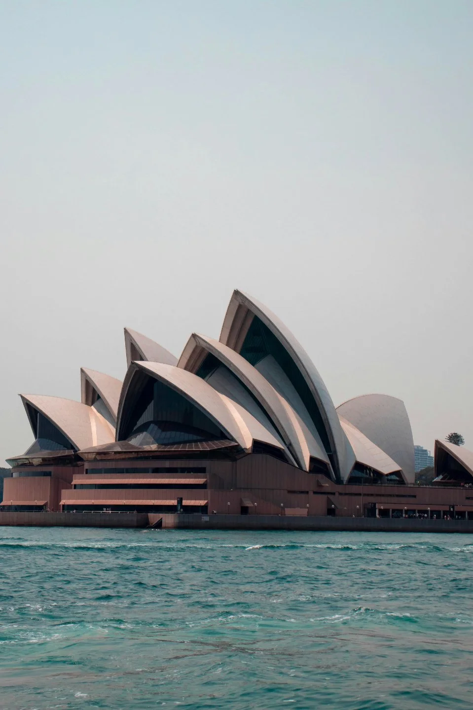 Sydney Opera House with water in foreground and overcast sky