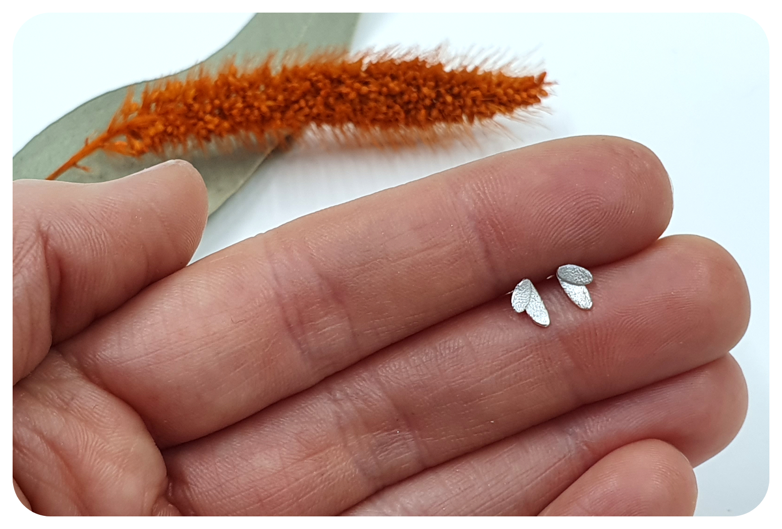 tiny petal studs in hand.png
