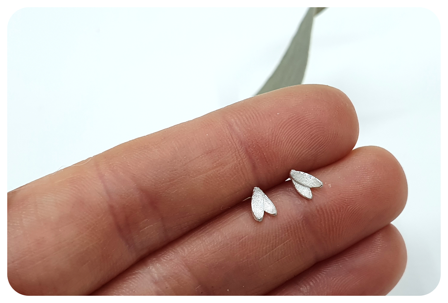 tiny doub petal studs in hand.png