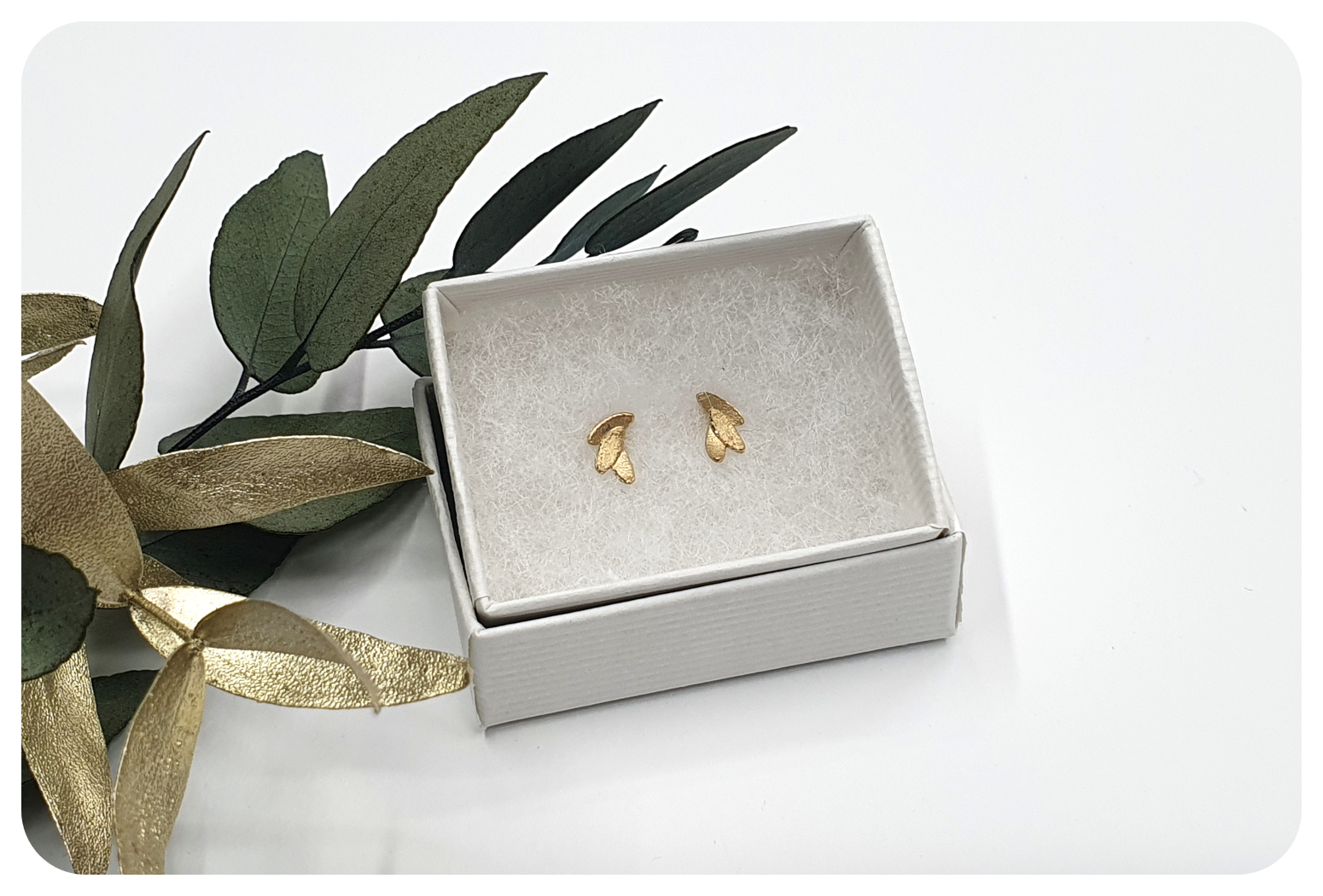 tiny gold leaves studs in box.png