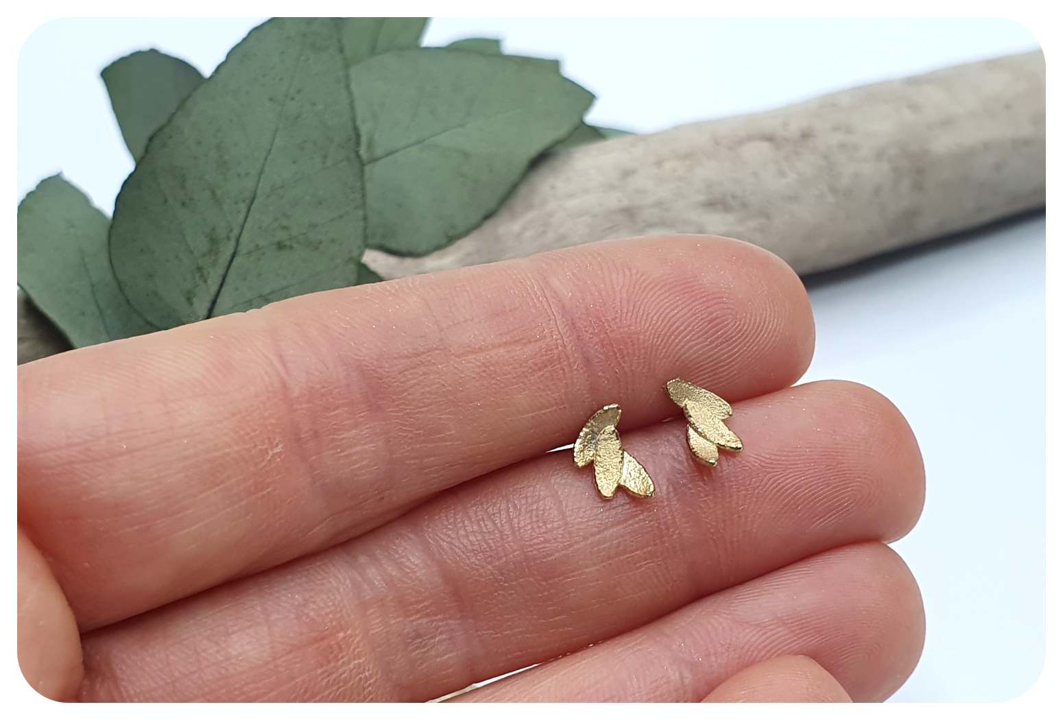tiny gold leaves studs in hands.png
