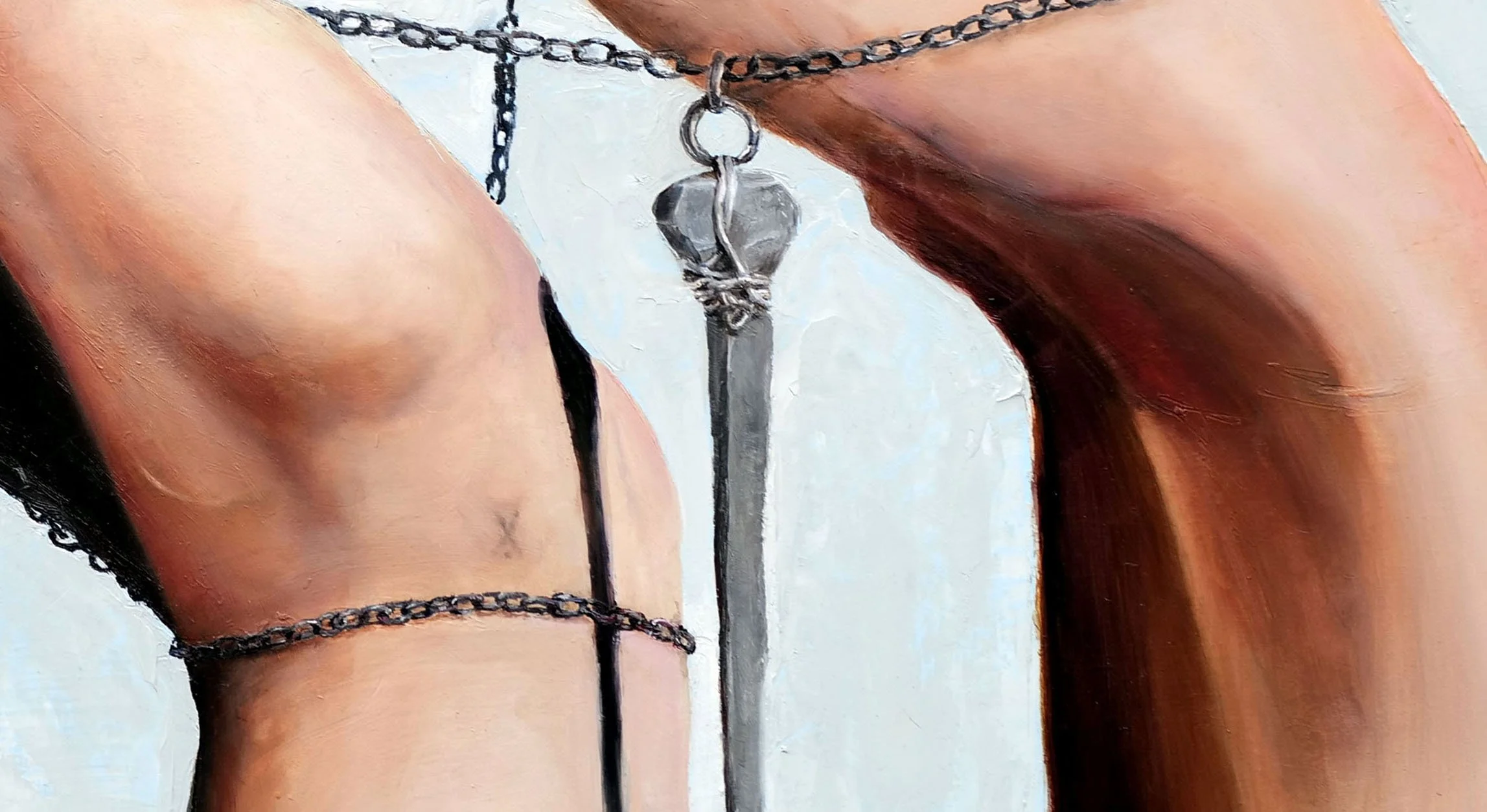 Close-up of a painting of person's wrists with a coffin nail suspended between them on chains.