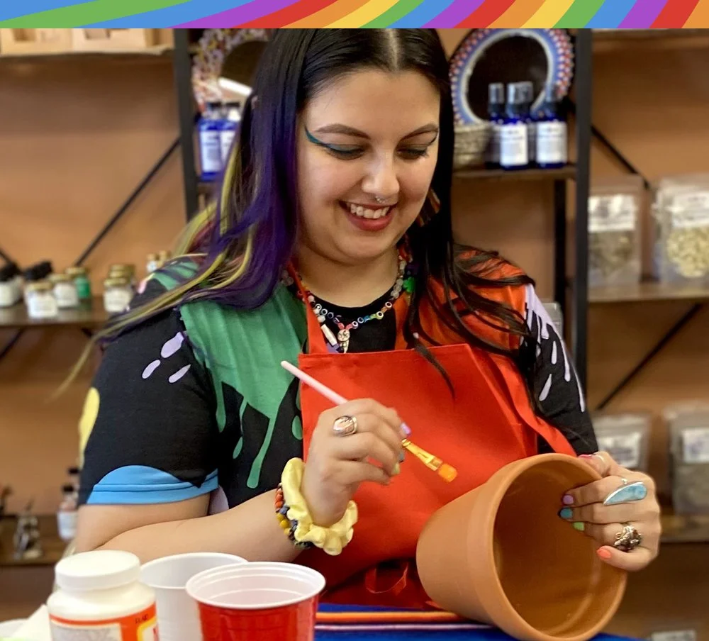 Mama Rainbow of A Meaningful Dream painting a flower pot during a School of Higher Consciousness class