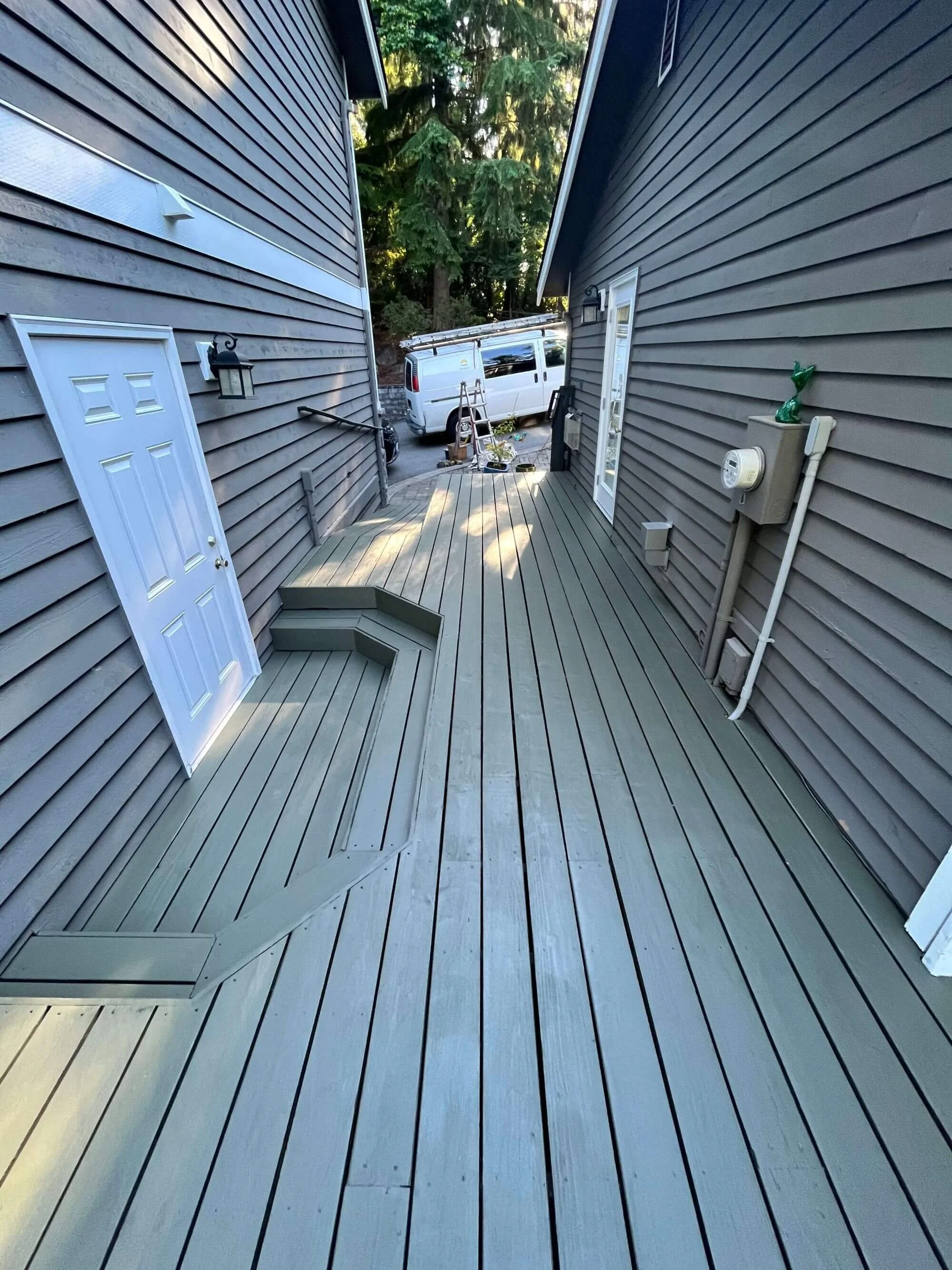 Unique decking passageway between two buildings at a Renton, WA home. Refinished by Gold Mountain Contracting.