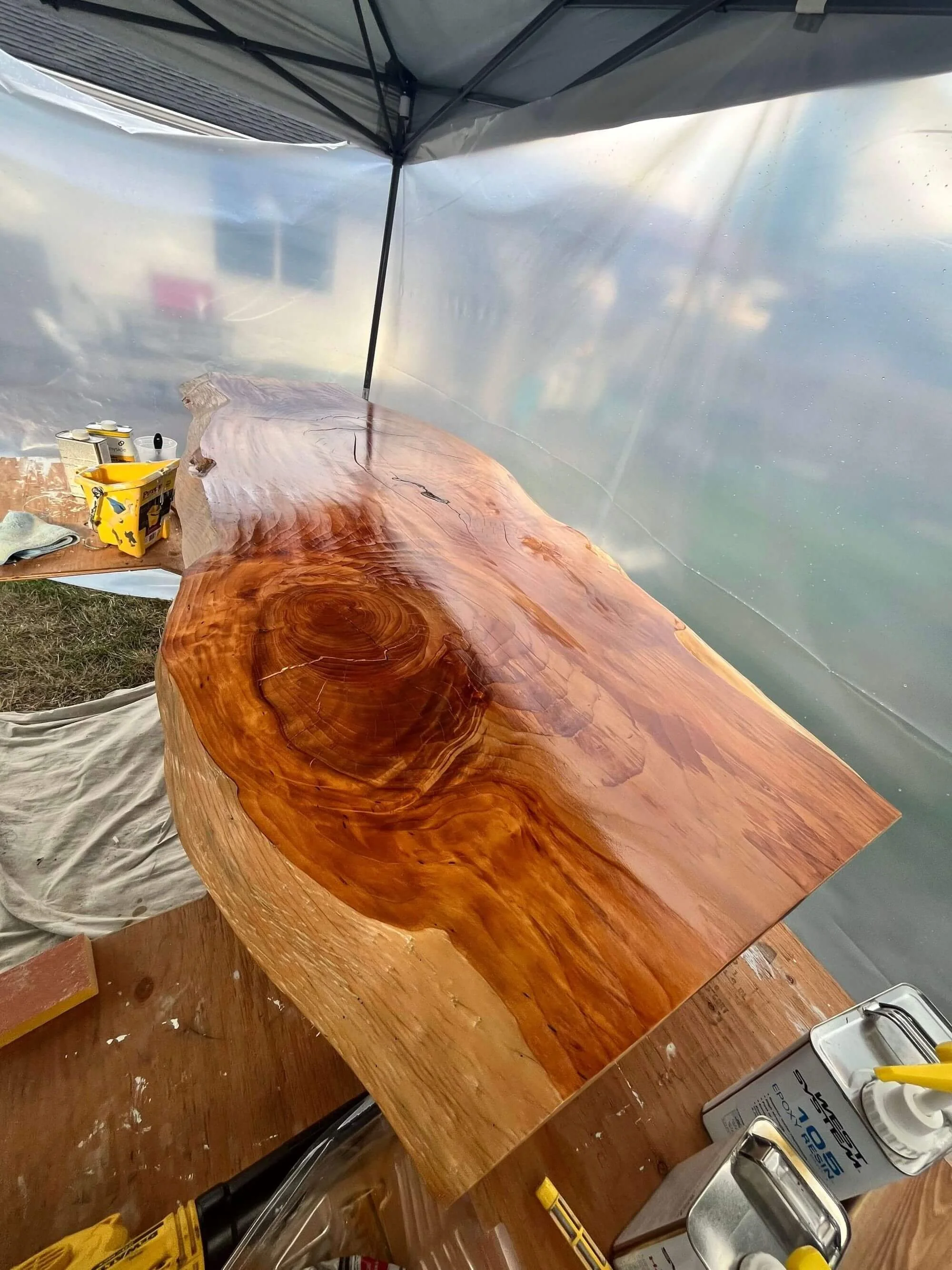 Protecting this live edge wooden table from the Seattle elements with a tent while refinishing it at a Magnolia home.
