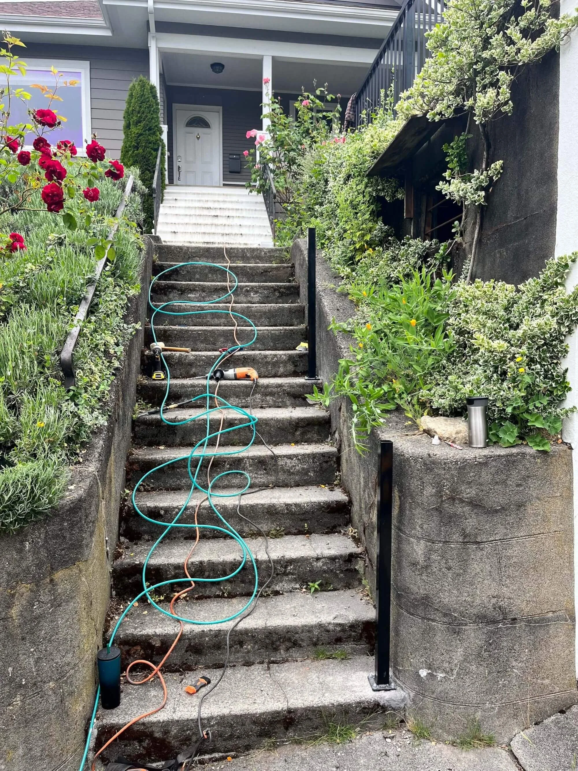 Metal handrail installation going in on an exterior staircase at a rental home in Seattle.