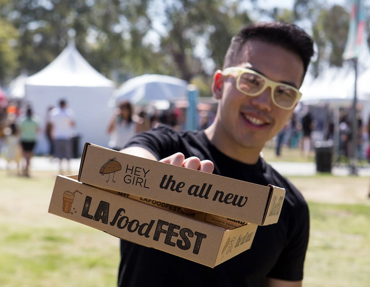 Man showing off our food trays — LA Food Fest | LA's original tasting event | June 29, 2019 at Santa Anita Park, Arcadia, CA