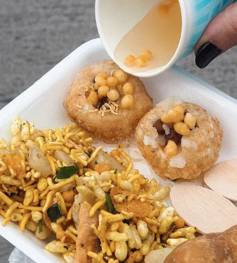 TUKDA Tangy Explosion Shots – Pani Puri | hollow semolina puff, fried crisp and filled with a spiced water mixed with vodka , tamarind chutney, potato, chickpeas and chickpea noodles. (V)