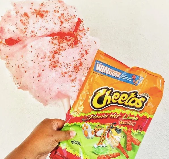   TWISTED FOR SUGAR    Flamin Hot Cotton Candy | A sweet corn cotton candy topped with everyones spicy favorite Flamin’ Hot Cheetos. Takis topping available for Vegans.    (V)   