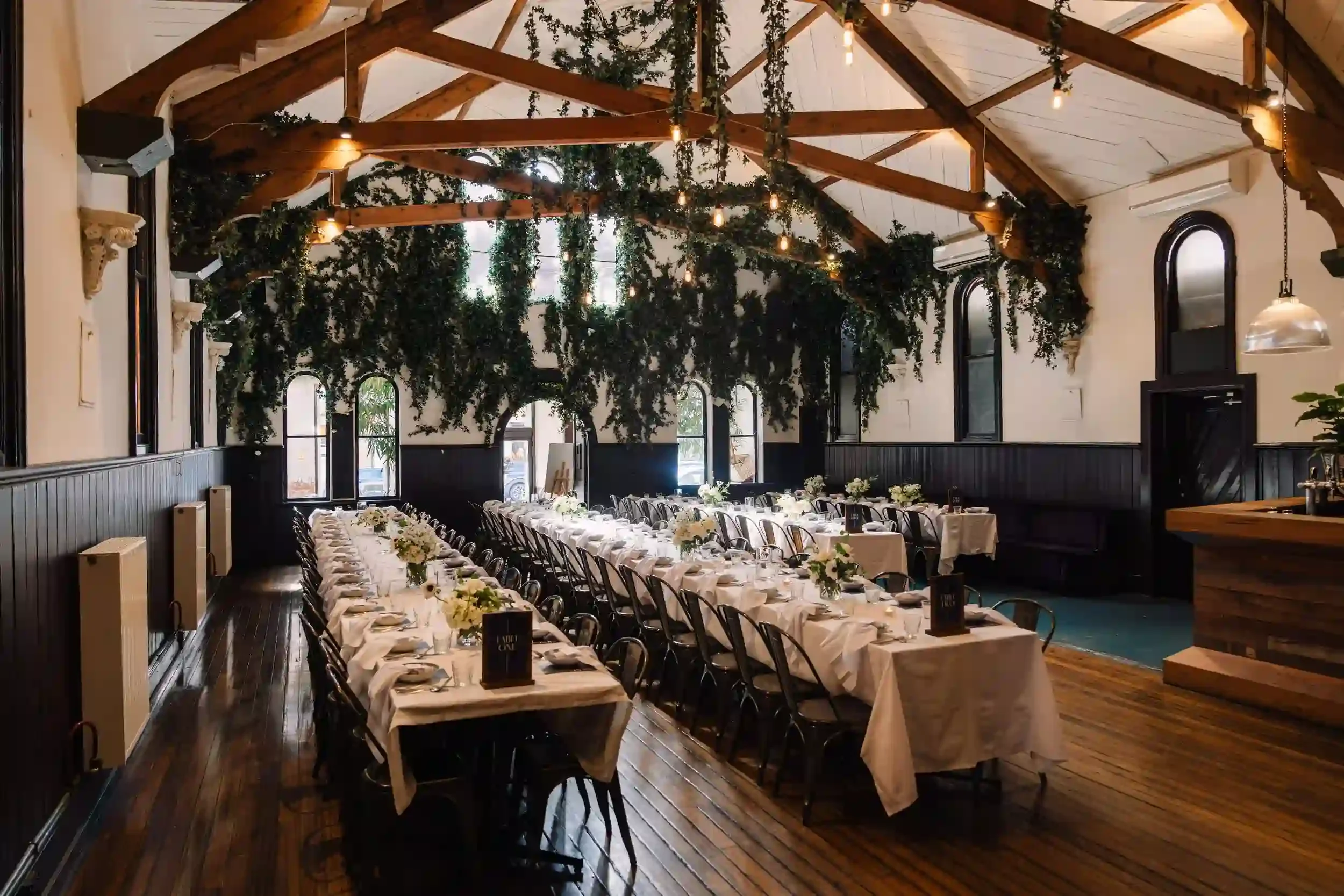 Elegant wedding reception setup at The Brunswick Mess Hall with long banquet tables and lush greenery — perfect Melbourne event venue for photo booth hire by Pixel Booth.