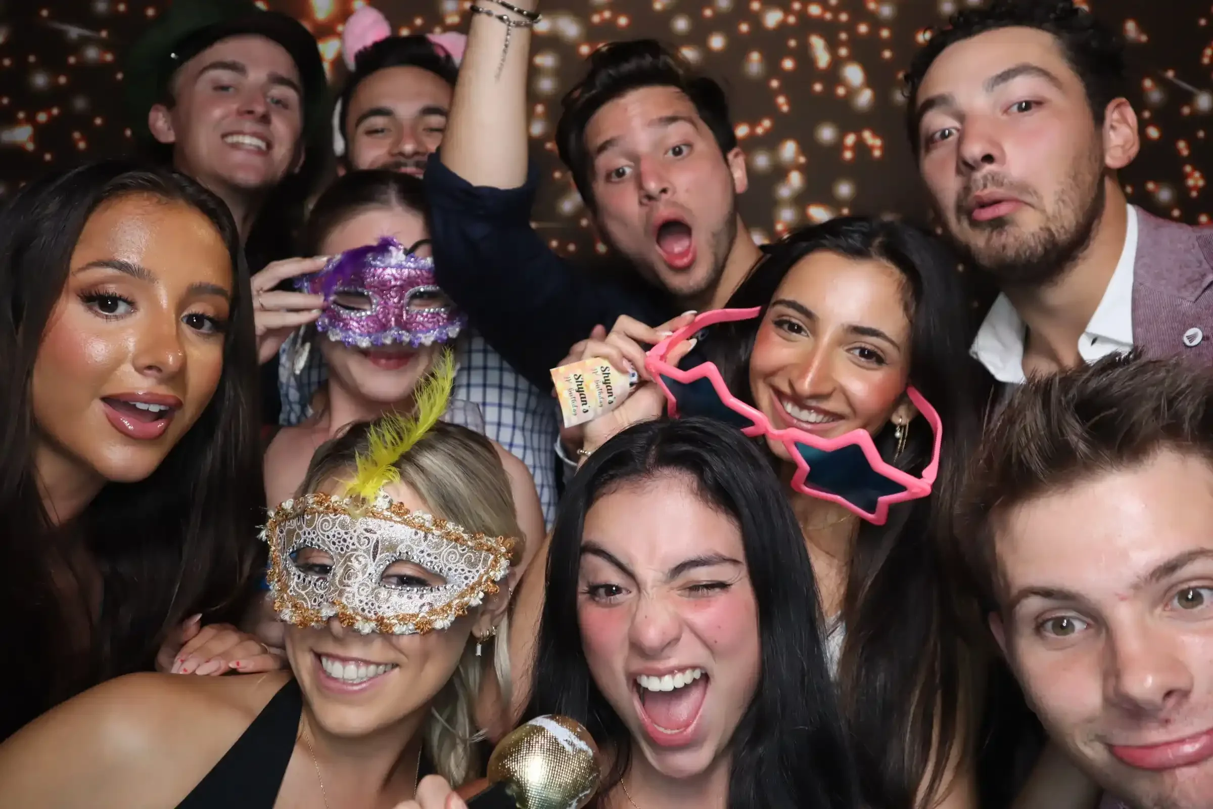 Group of friends posing with masks and props in a Pixel Booth Melbourne CBD photo booth during a lively party.