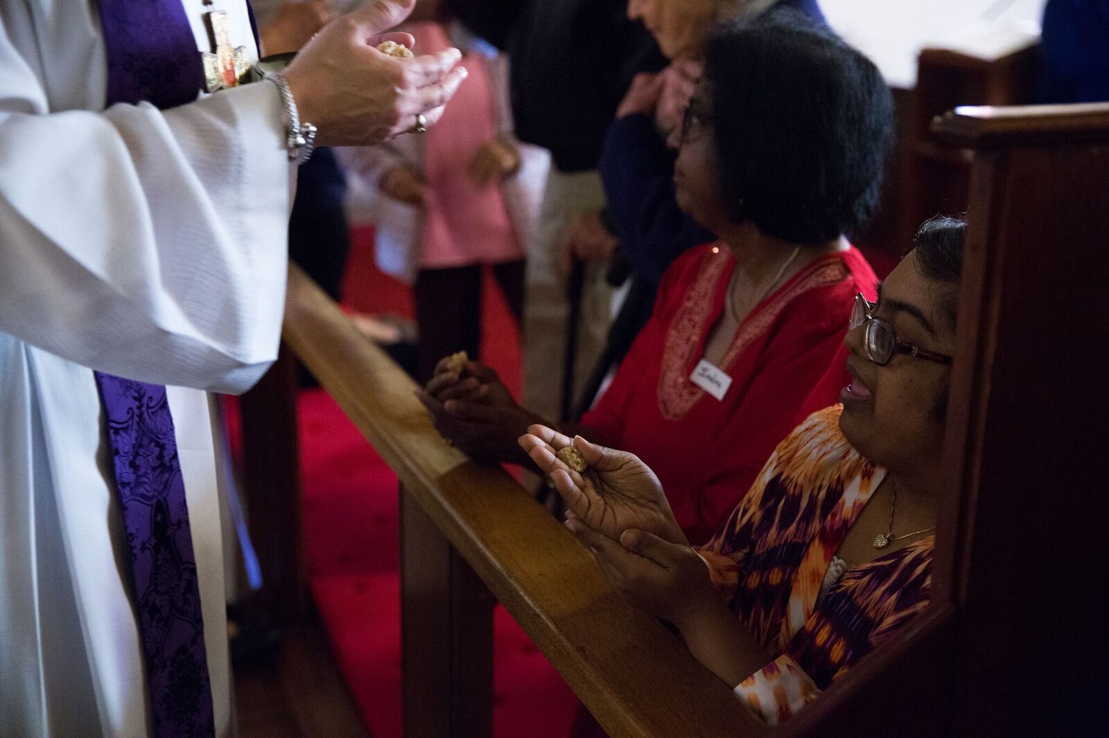 Jill gives communion to Indira and Arshni.jpeg