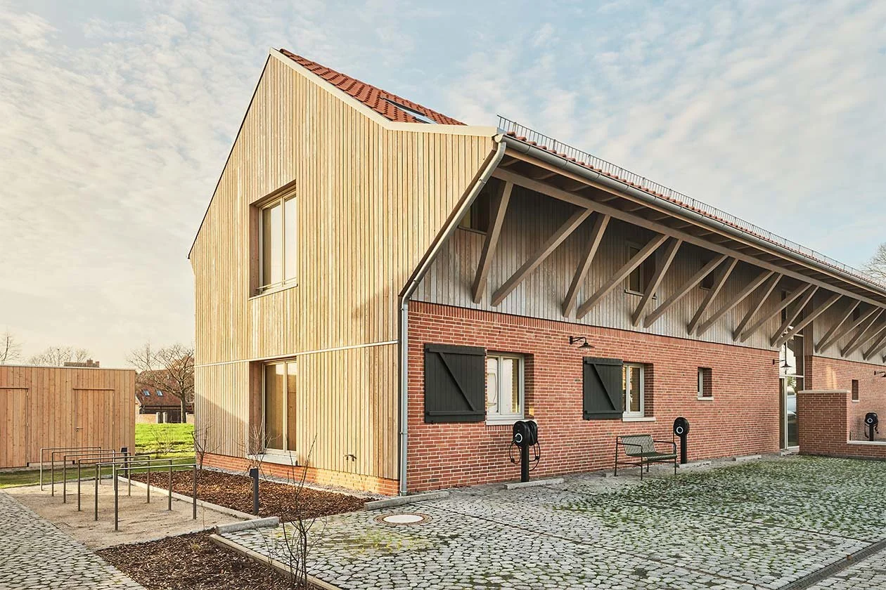  Der großzügige Dachüberstand der Remise prägt den Hofraum und schafft geschützte Übergänge zwischen Innen- und Außenbereich. So entsteht ein flexibel nutzbarer, gemeinschaftlich geprägter Freiraum mit vielfältigen Aufenthaltsqualitäten. 