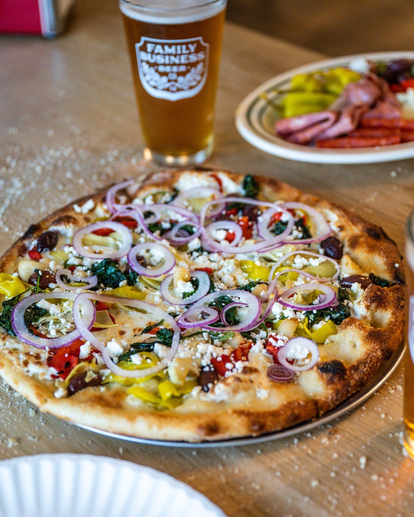 Who needs a summer vacation when we've got the Greek right here!? 😋 Slice into Olive Oil, Mozzarella, Feta Cheese, Shaved Red Onions, Artichoke Hearts, Garlic, Spinach, Fire Roasted Red Pepper, Pepperoncini Peppers, and Kalamata Olives all month lon
