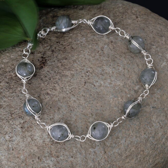Known for its chameleon ways and often associated with transformation, it is no wonder that labradorite is kept close during times of change.

Made from sterling silver wire, this herringbone weave bracelet accented with labradorite creates a captiva