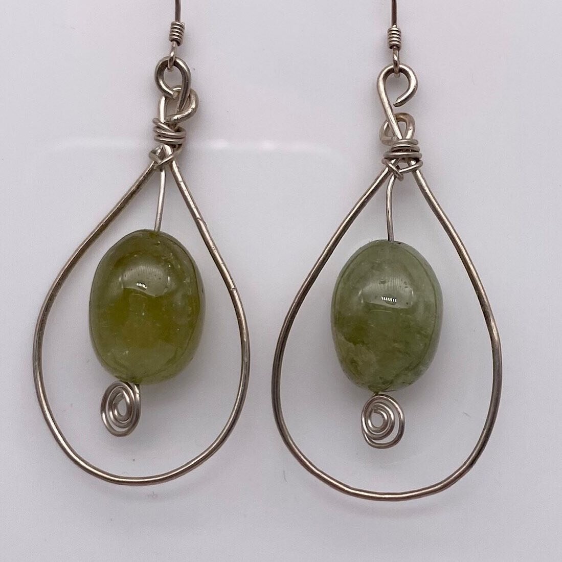 Reminiscent of Gooseberries who share the same colour and shape, green Garnets have long been used to promote spiritual growth as we manifest our goals.

Wire wrapped, these sterling silver and green Garnet earrings hang at 2.5&rdquo;.

Made exclusiv