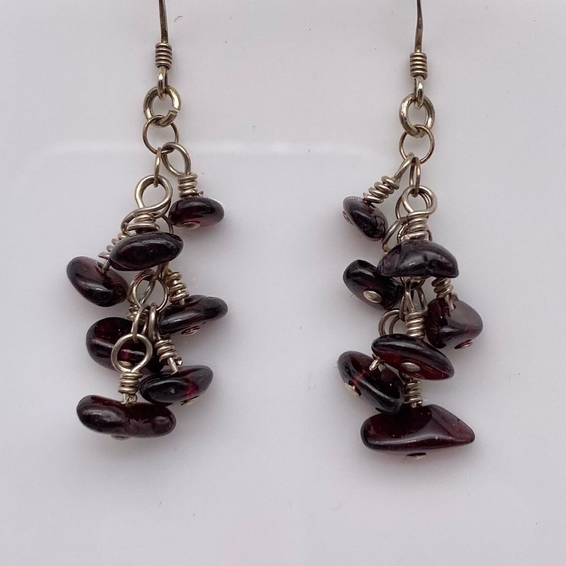 Believed to resemble the seeds of a pomegranate, which are symbolic of life and power, this January birthstone is often thought to promote good health.

Measuring approximately 1.5&rdquo; long, these sterling silver earrings sport 7 Garnet chips  mea