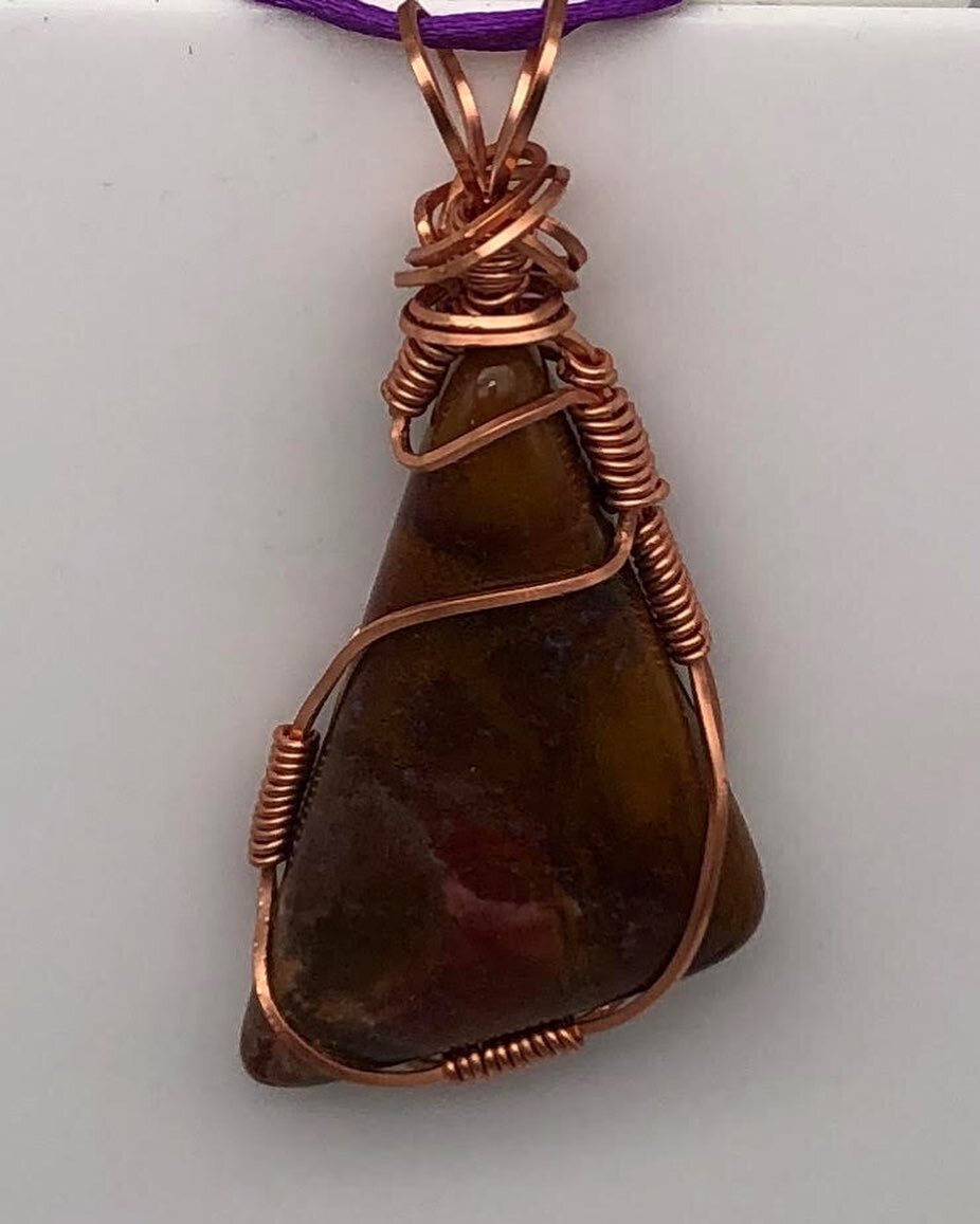 Though the name may mean treasurer, Jasper is often known for its nurturing properties as it brings tranquility and protection in trying times.

Securely fastened in an intricate wrap of copper wire resides a 1.25 inch wide triangle of jasper.

With 