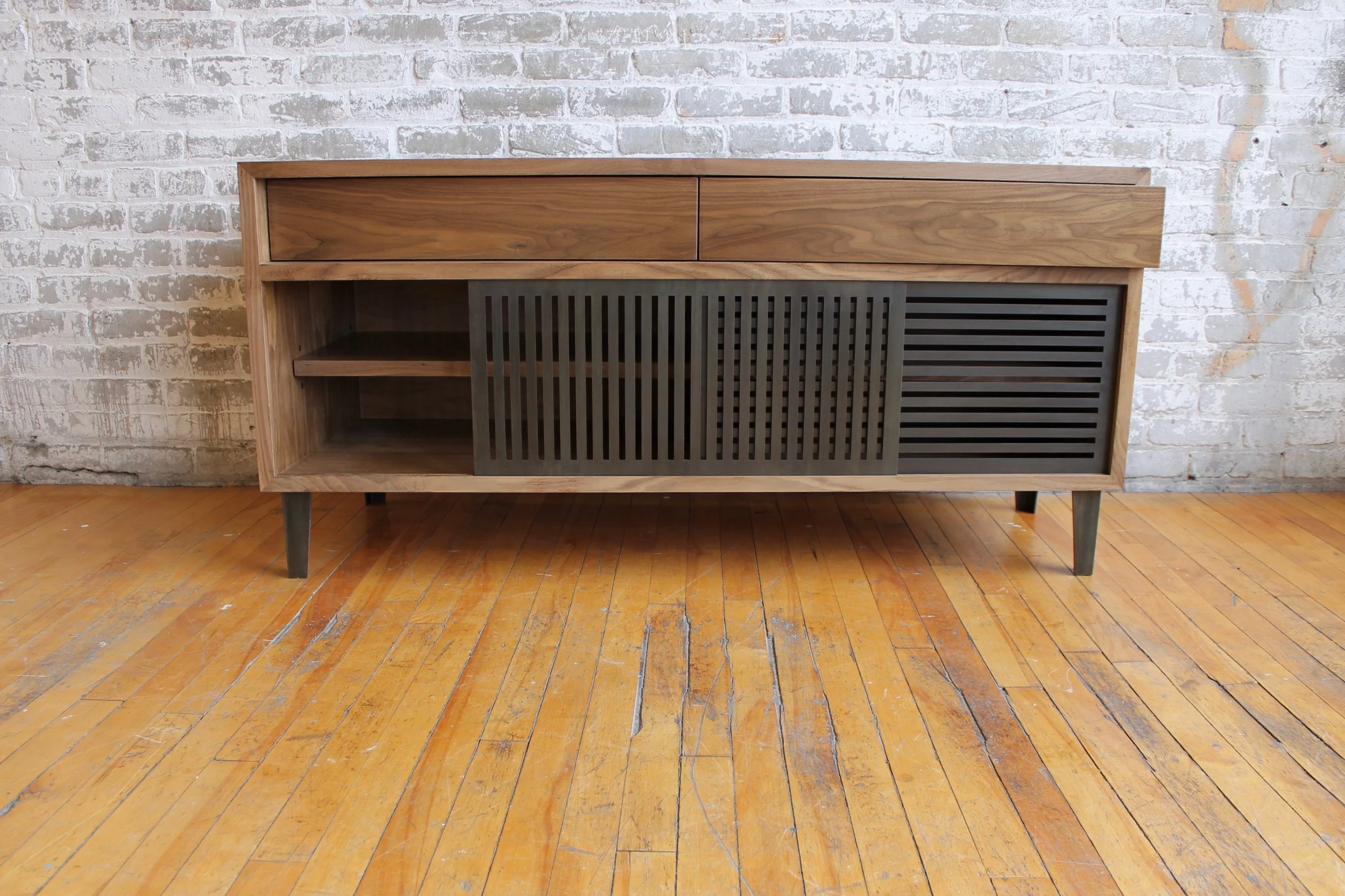 Walnut credenza with laser cut steel sliding doors.