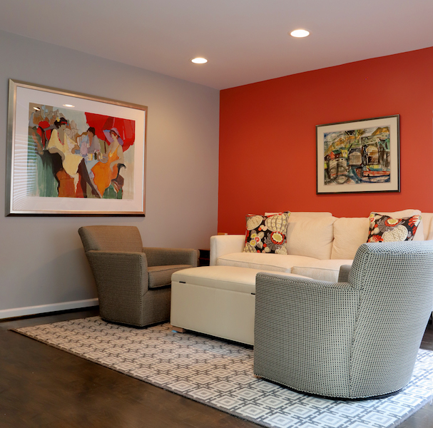 Taking a narrow space and converting it into a cozy conversation-friendly TV viewing area with swivel chairs as well as a storage ottoman that holds throws. A great reading area in bedroom.