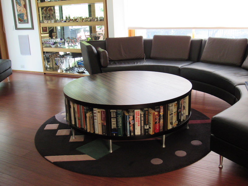Building a custom table in zebra wood to display books with a storage cabinet on back side for throws as well as matching the sofa legs created a unique look.