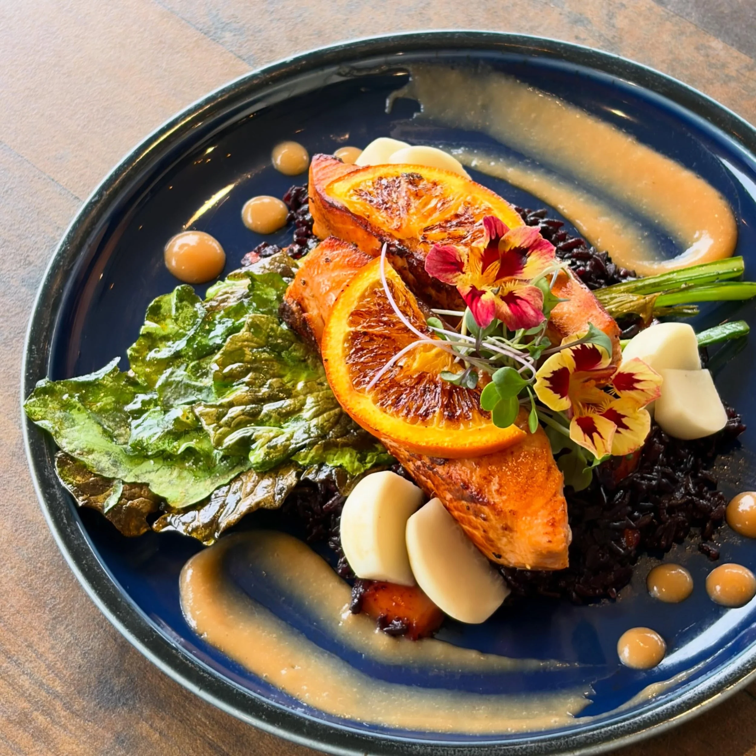 A lil&rsquo; dinner special for this evening! Citrus herb marinated salmon, grilled turnip greens &amp; pickled turnips, mango forbidden rice, rhubarb &amp; mango puree, and grilled orange. ✨

Reservations are available for dinner and all day on Sund