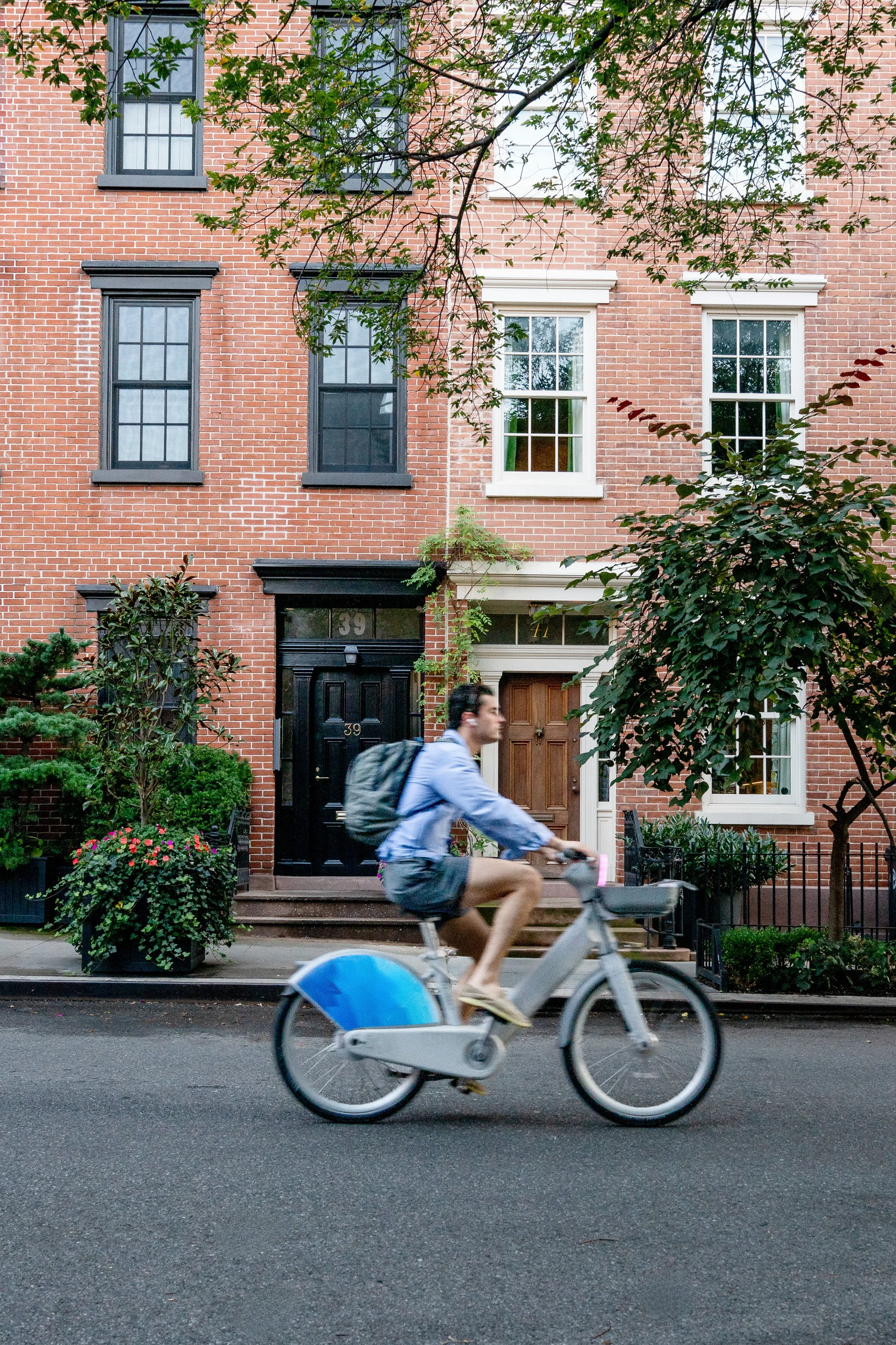 Biker passing by New York brownstones