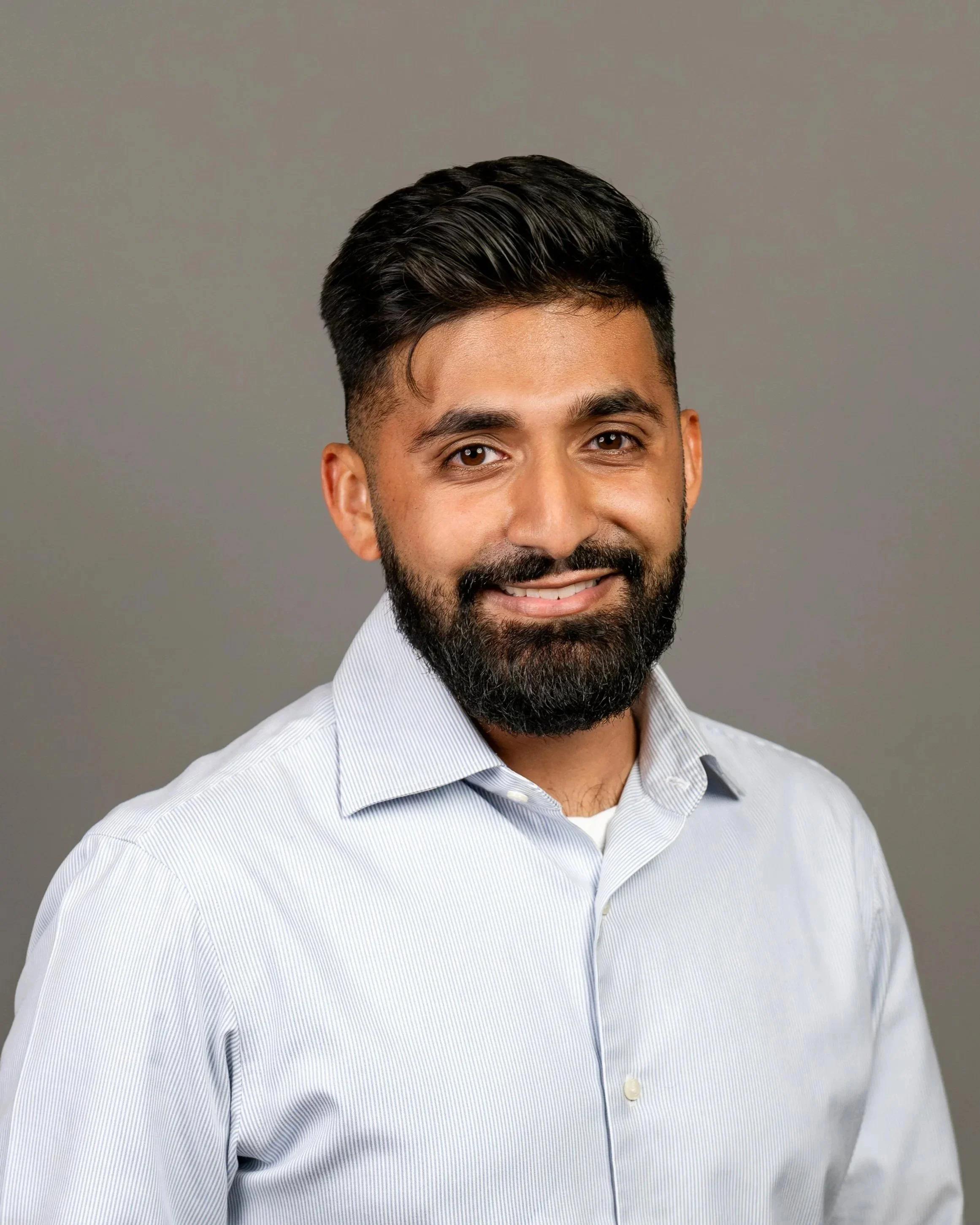 headshot picture of male Asaim Yahya on dark gray seamless back drop.