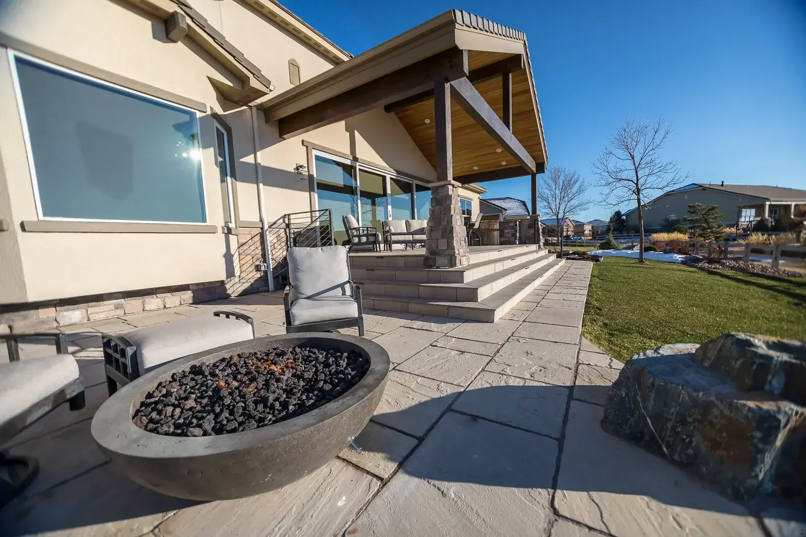Natural stone patio with seating, fire pit and steps up to stone deck