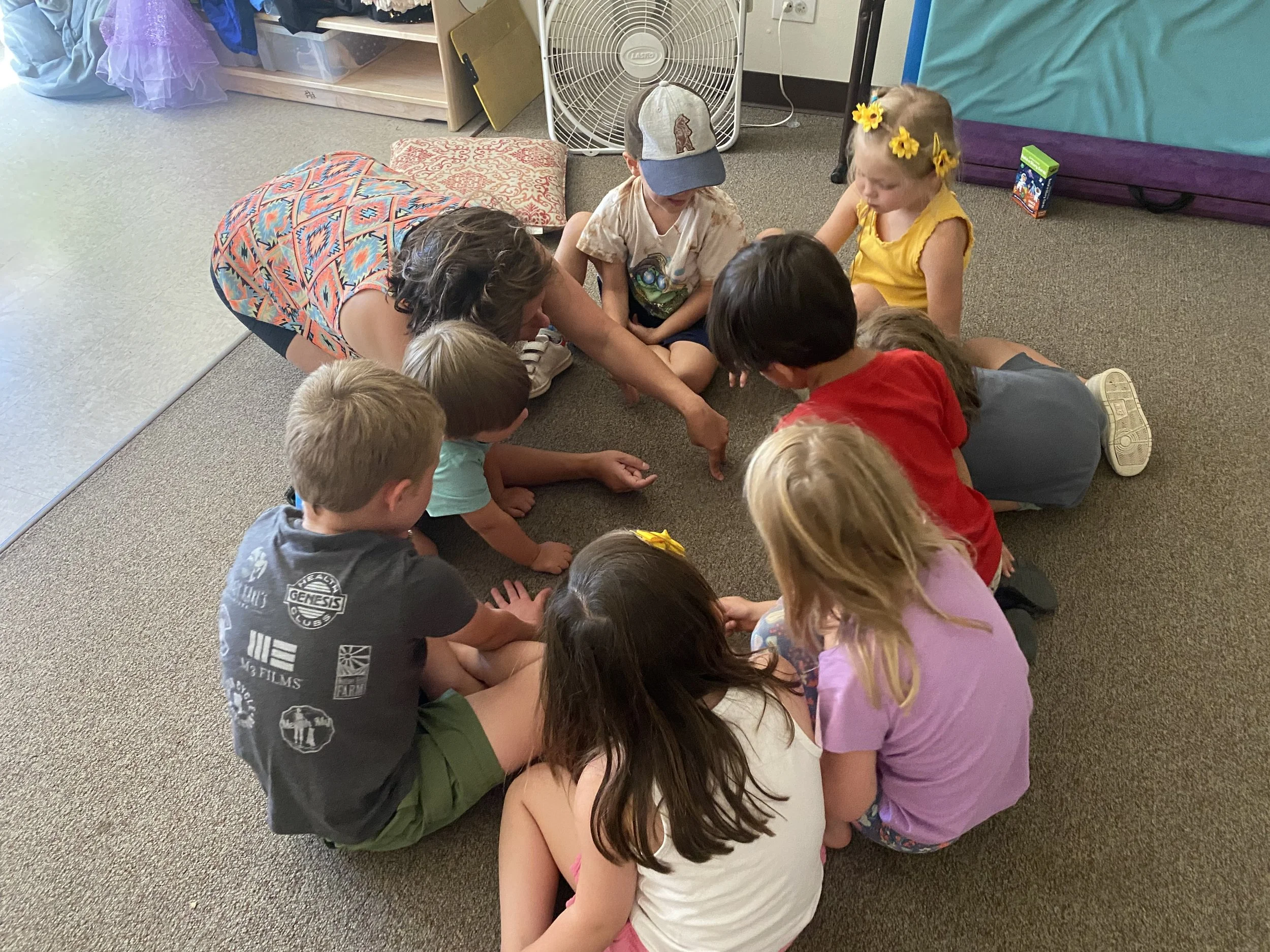 eight children sitting on the floor in a circle