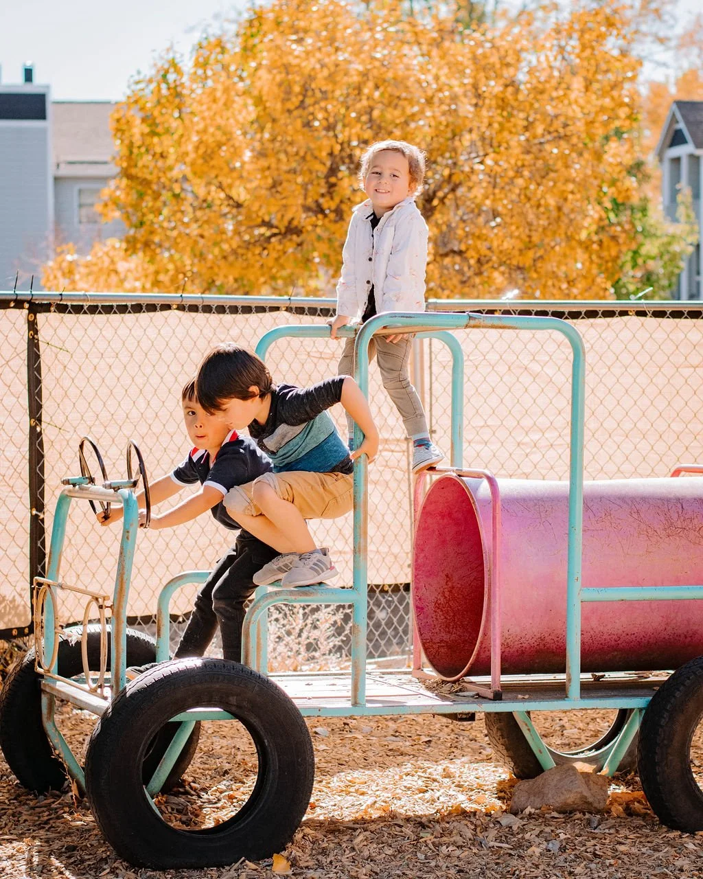 three young boys playing on playground equipment