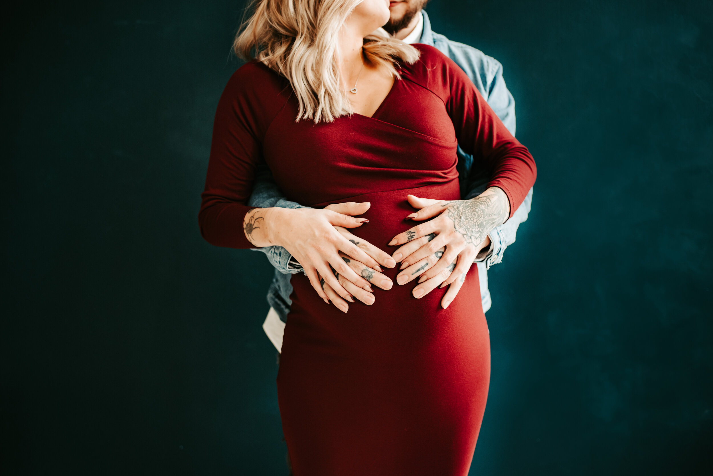 Maternity photograph of mom and dad holding hands on baby bump