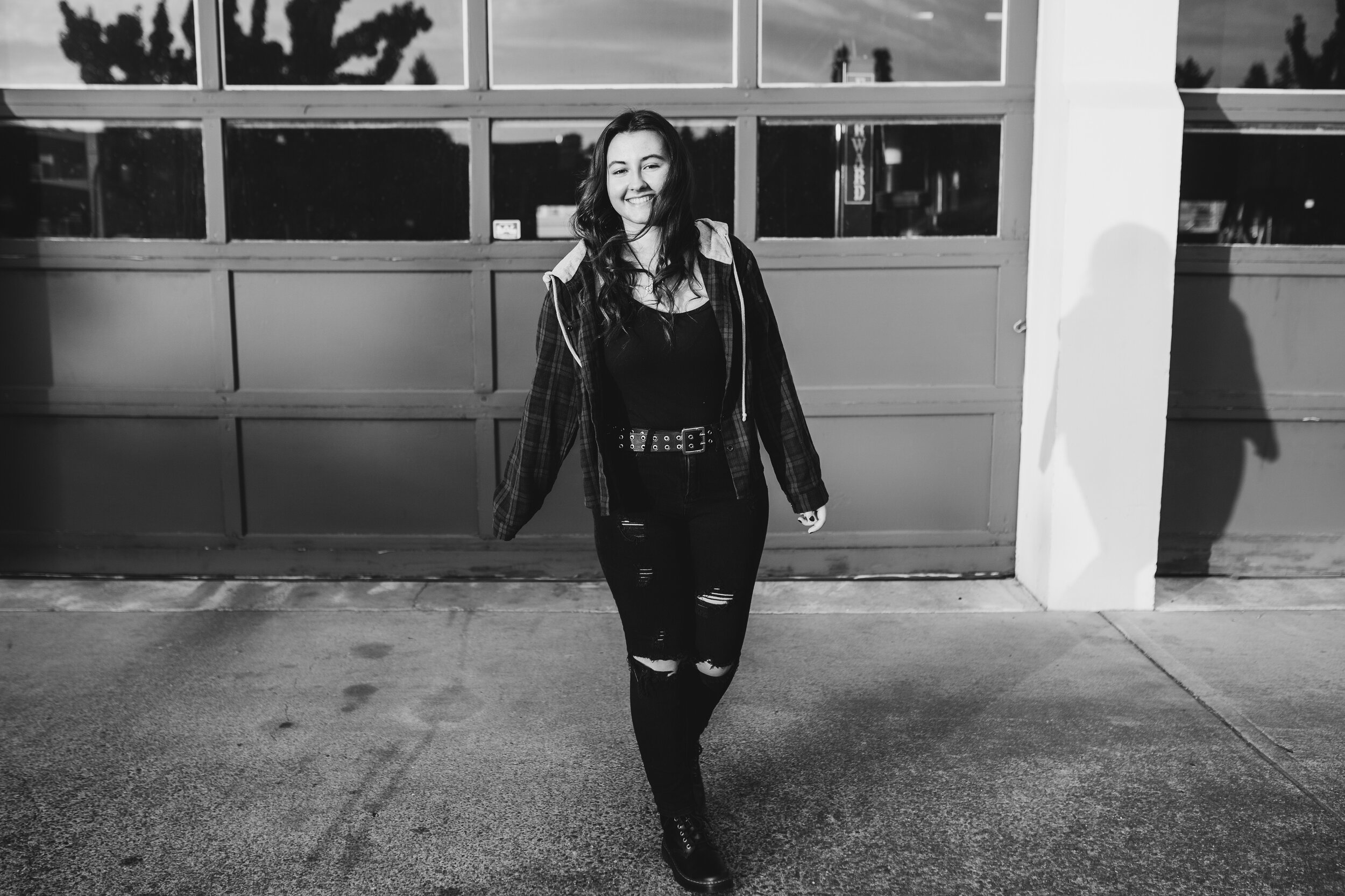 Black and white image of senior girl walking across the street