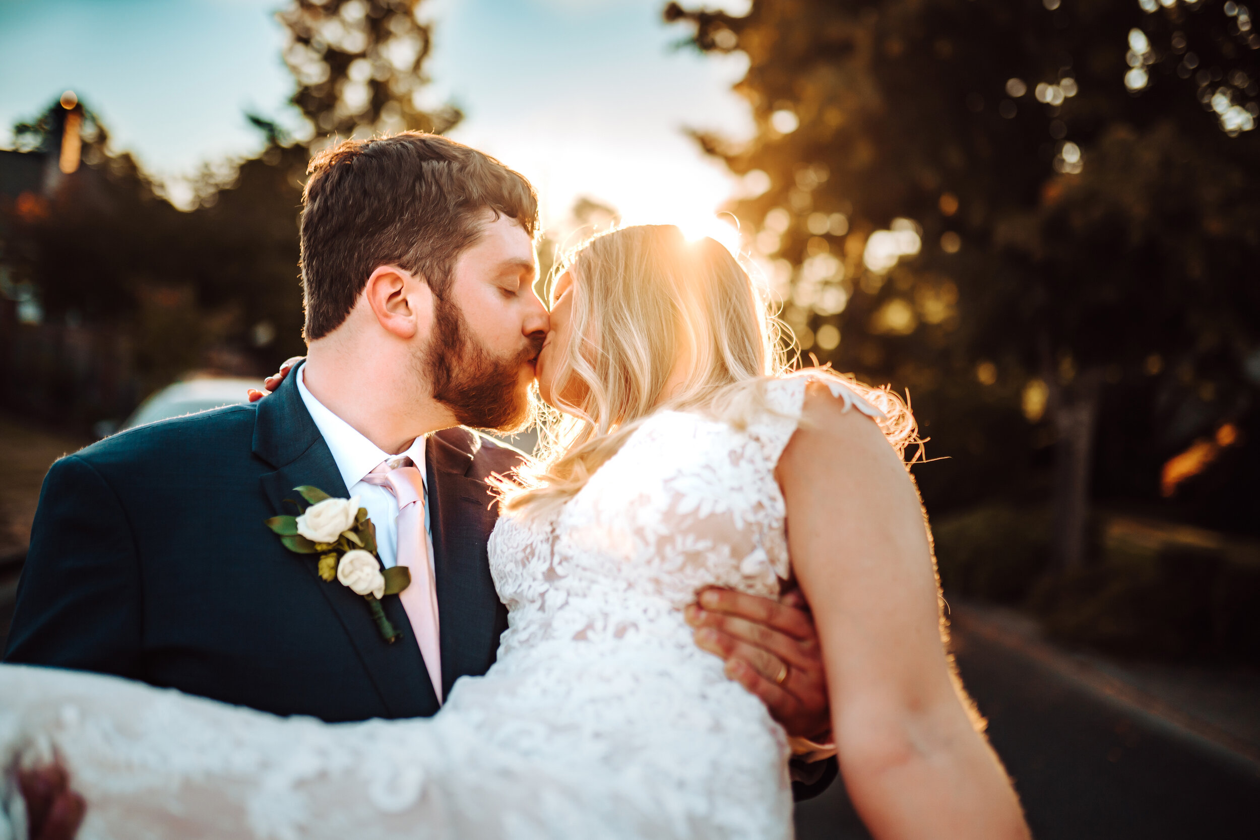 Groom holds bride and share a kiss at their wedding