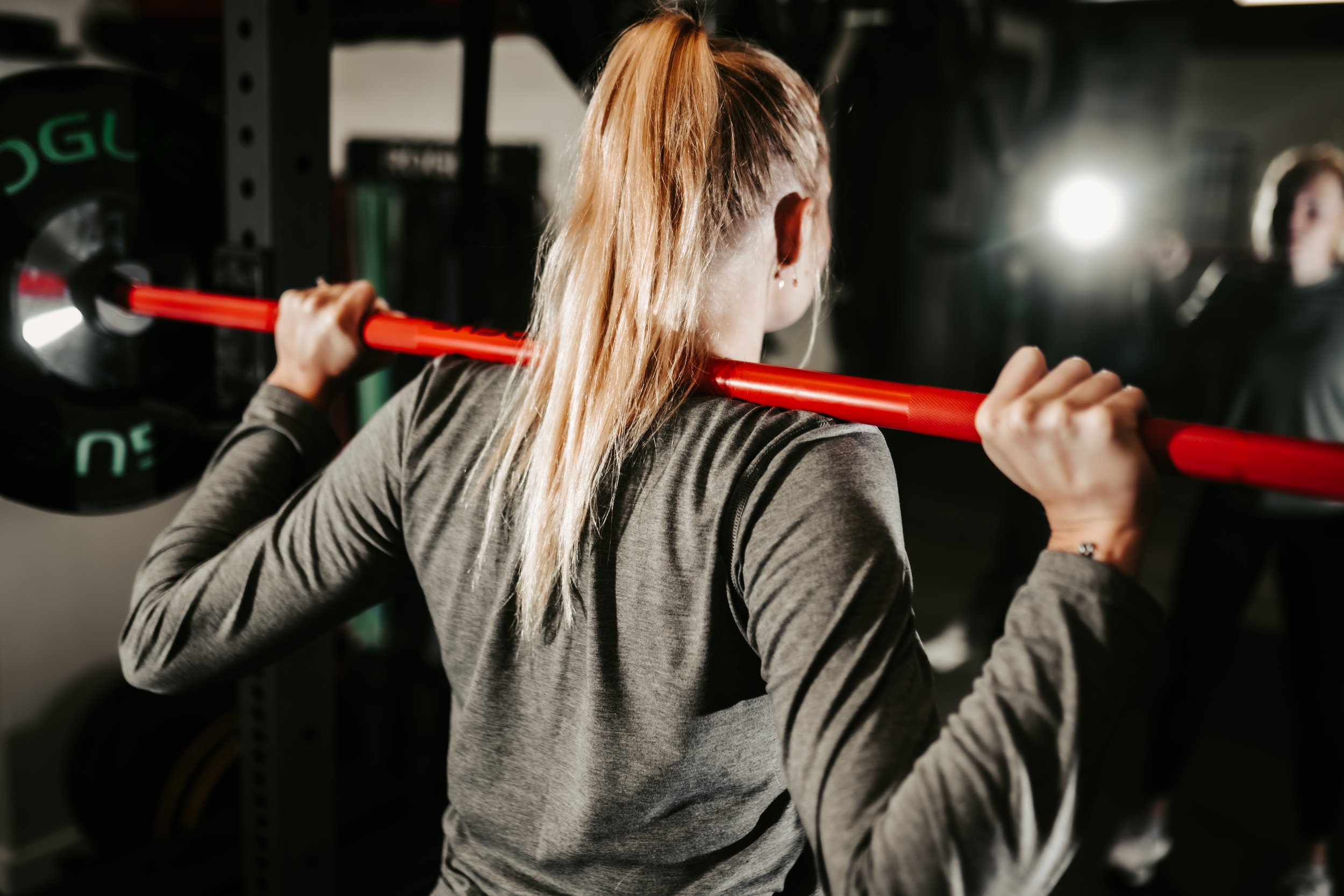 Female athlete squats with a weight bar