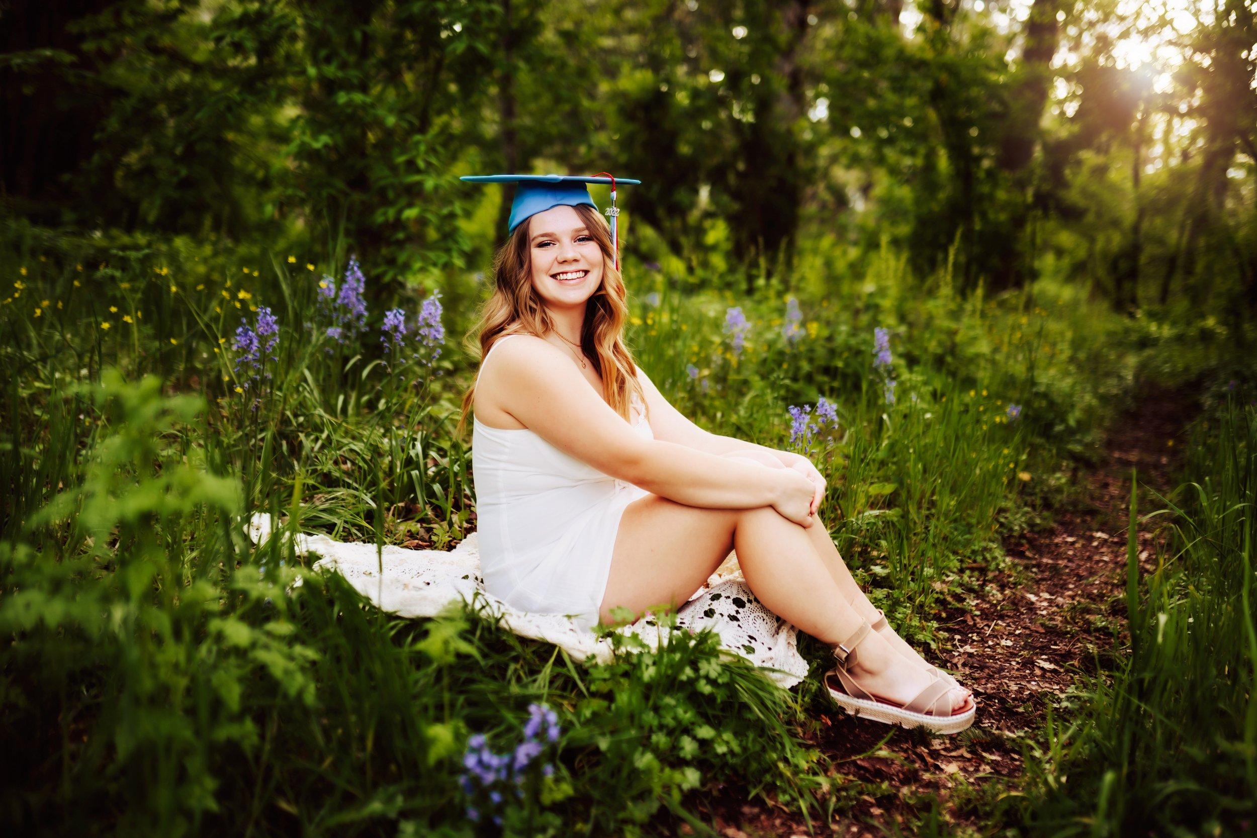 Graduating senior sitting in wildflower field