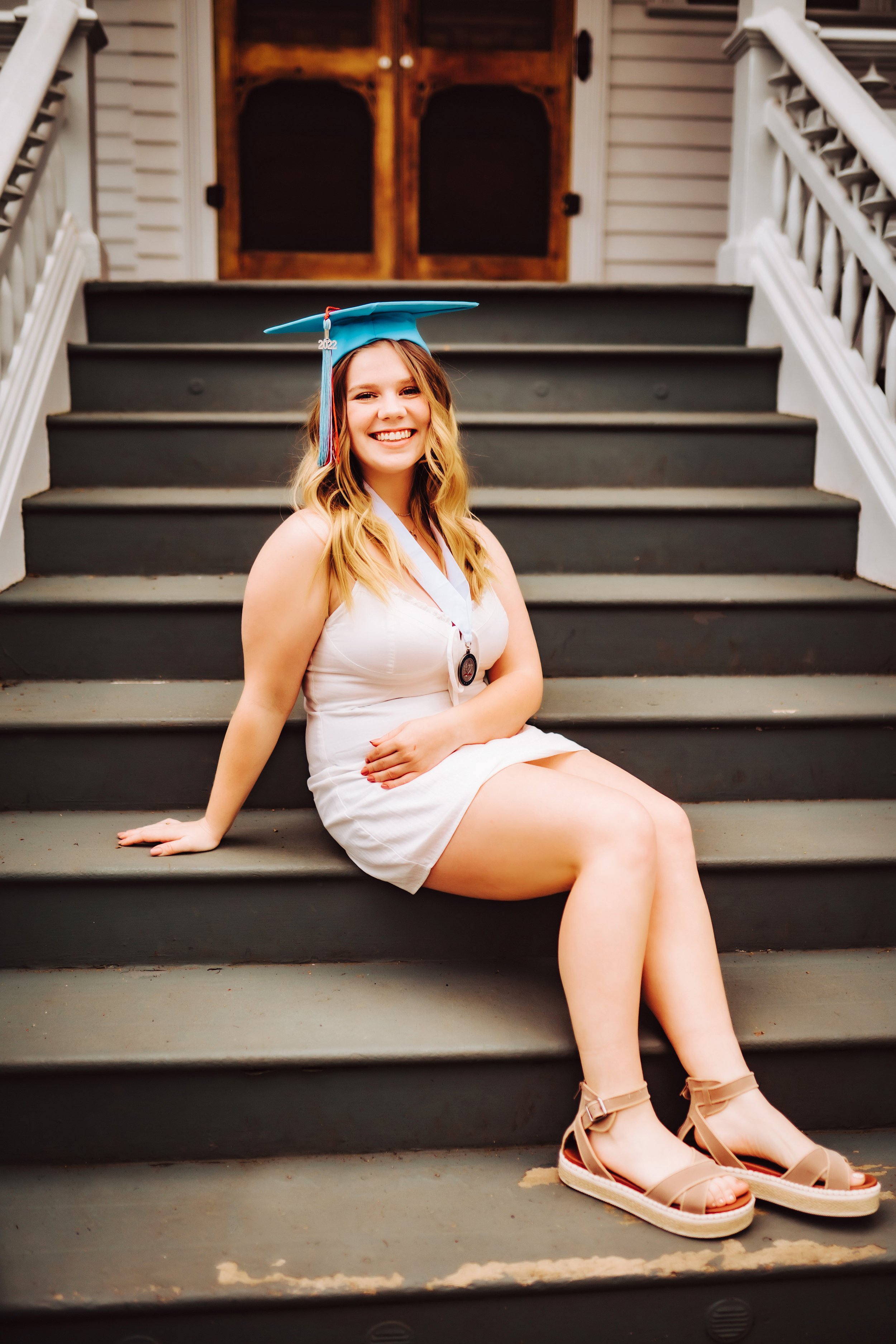 Girl sitting on steps with graduation cap